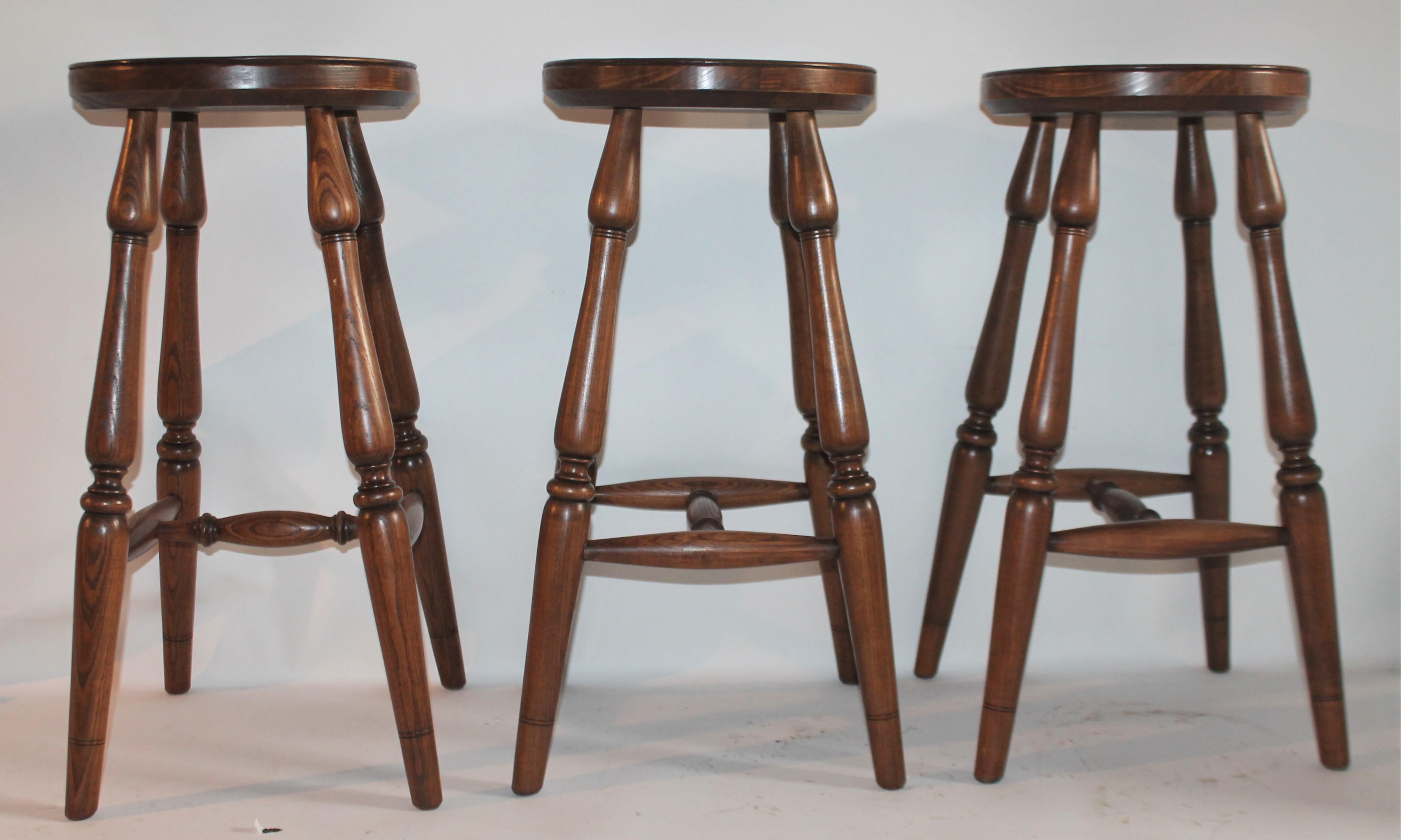 Set of three Old Hickory Furniture Company bar stools in dark wood finish. Fantastic plank seats.