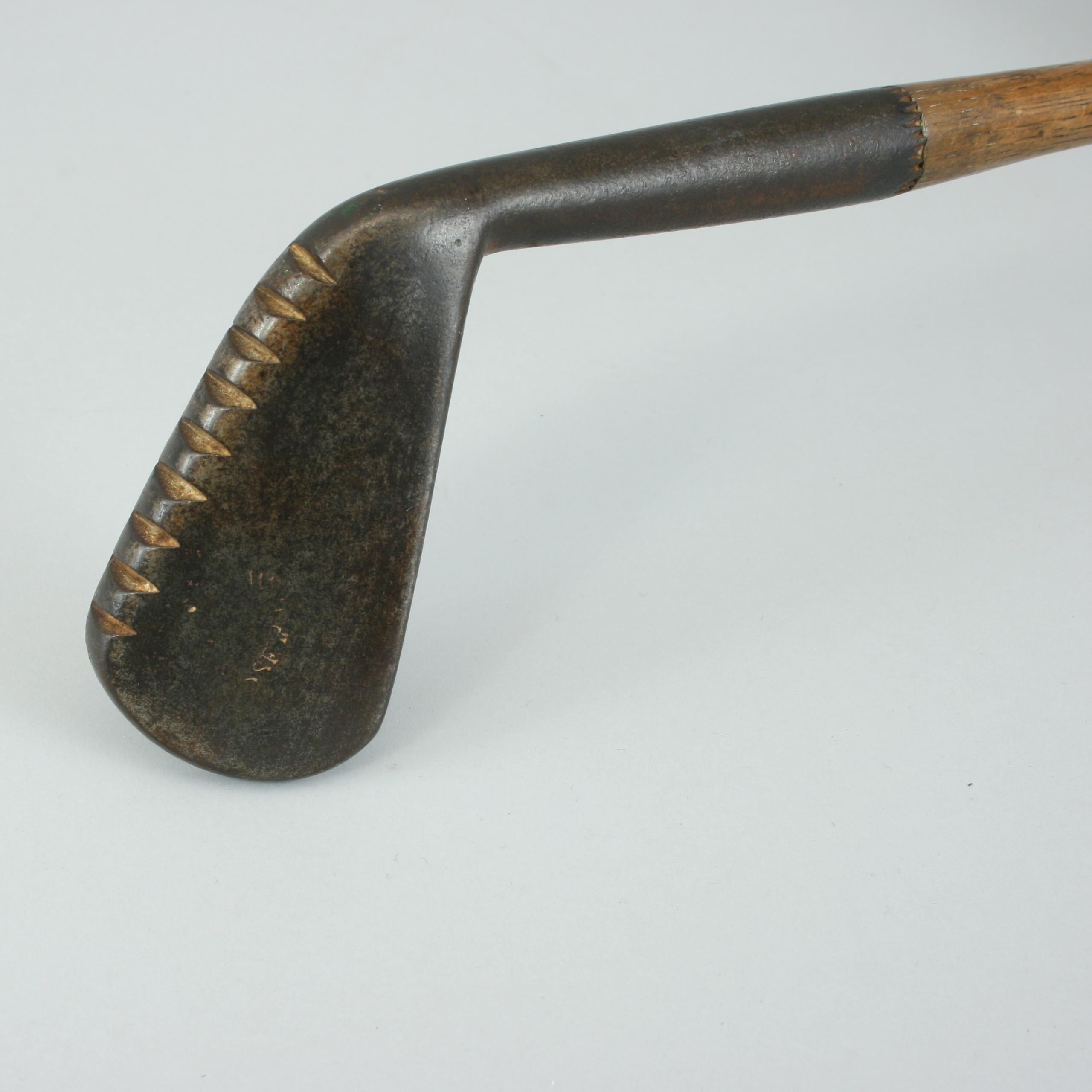 Vintage hickory golf club by Willie Park, Musselburgh.
An unusual smooth face lofting iron by Willie Park with a grooved sole. The sole of the club has small teeth notched out of it. On the back of the head is the remains of the stamp W.PARK,