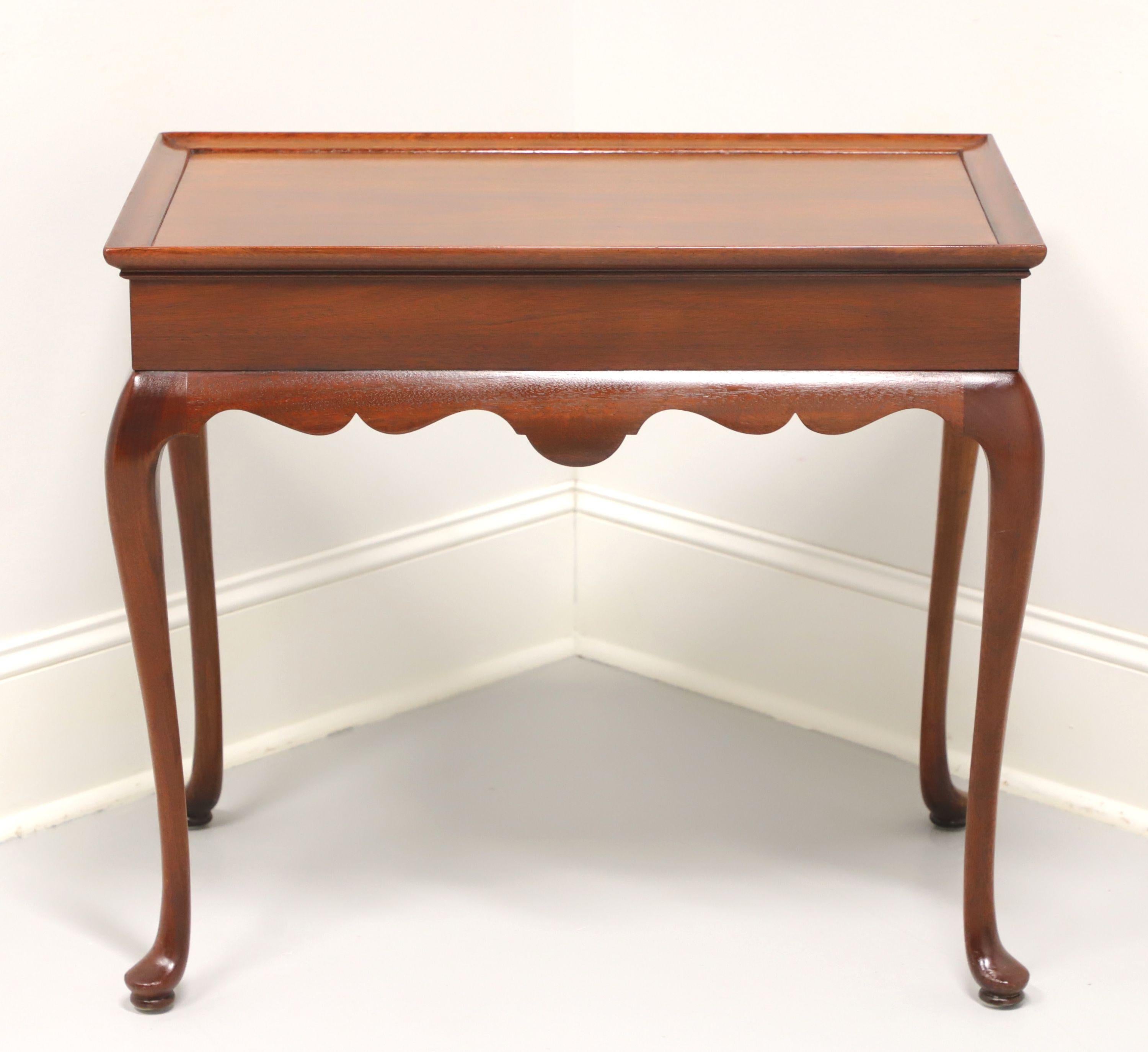 A tea table in the Queen Anne style by Hickory Furniture Company. Solid mahogany, two side slide out trays with brass knobs, carved apron, tapered legs and pad feet. Made in North Carolina, USA, in the late 20th century.

Style #: 760-76

Measures:
