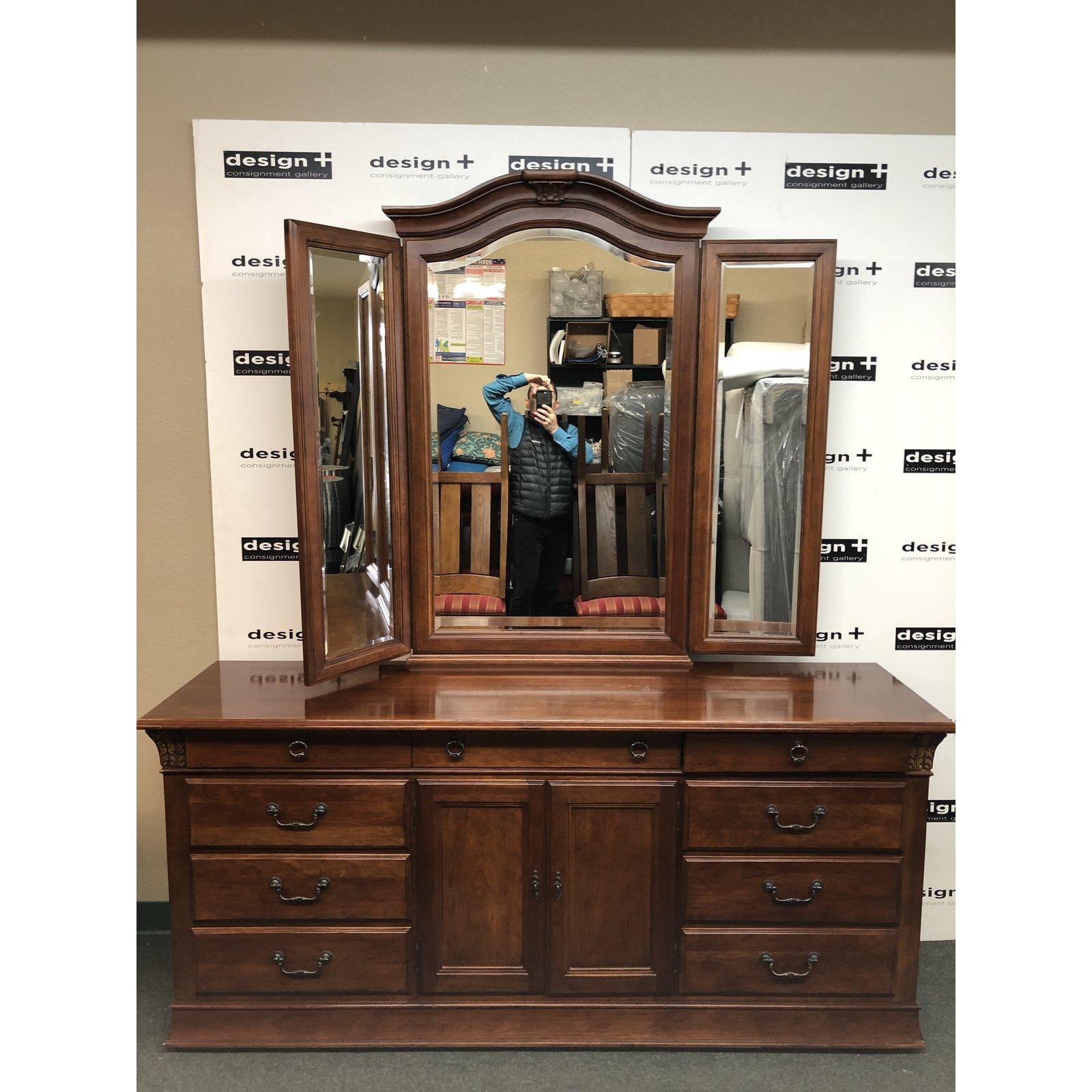 A traditional double dresser by Hickory white. Crafted of maple solids and cherry veneers, the finish has light distressing and lovely carved details. Nine drawers and adjustable shelf allows for ample storage. Fittings are antiqued bronze. Three