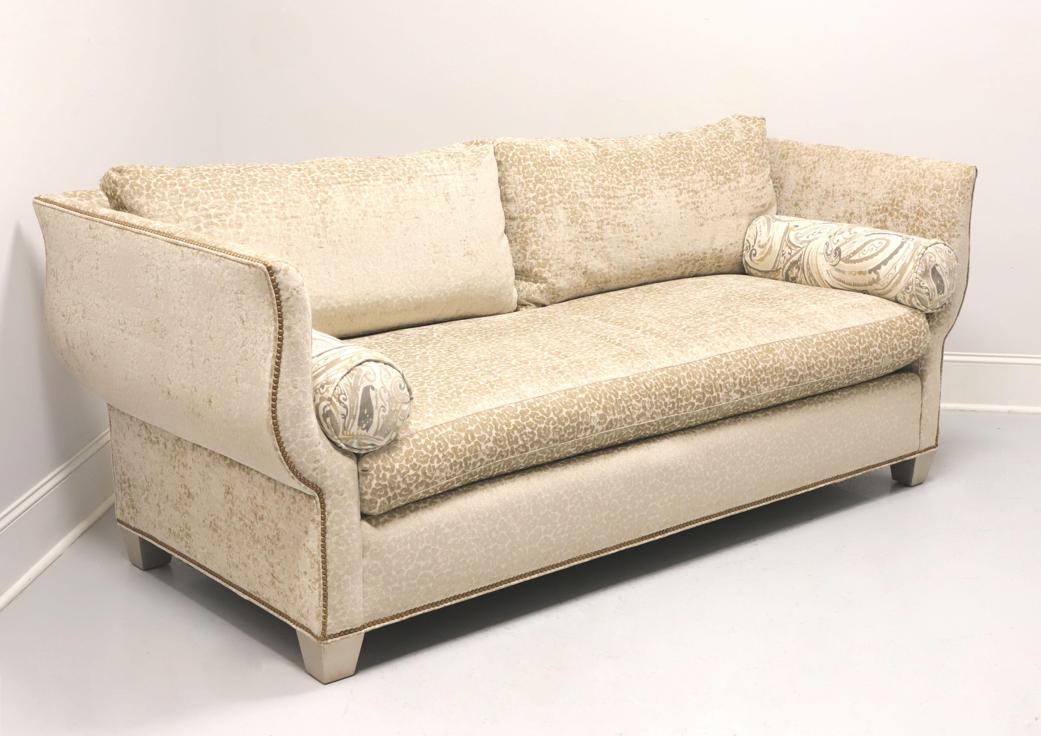 A Transitional style sofa by Hickory White Furniture. Hardwood frame construction; upholstered in a soft velvety beige color textured leopard print fabric, Knole style arms & back, brass nailhead trim, single reversible bottom cushion, Dual