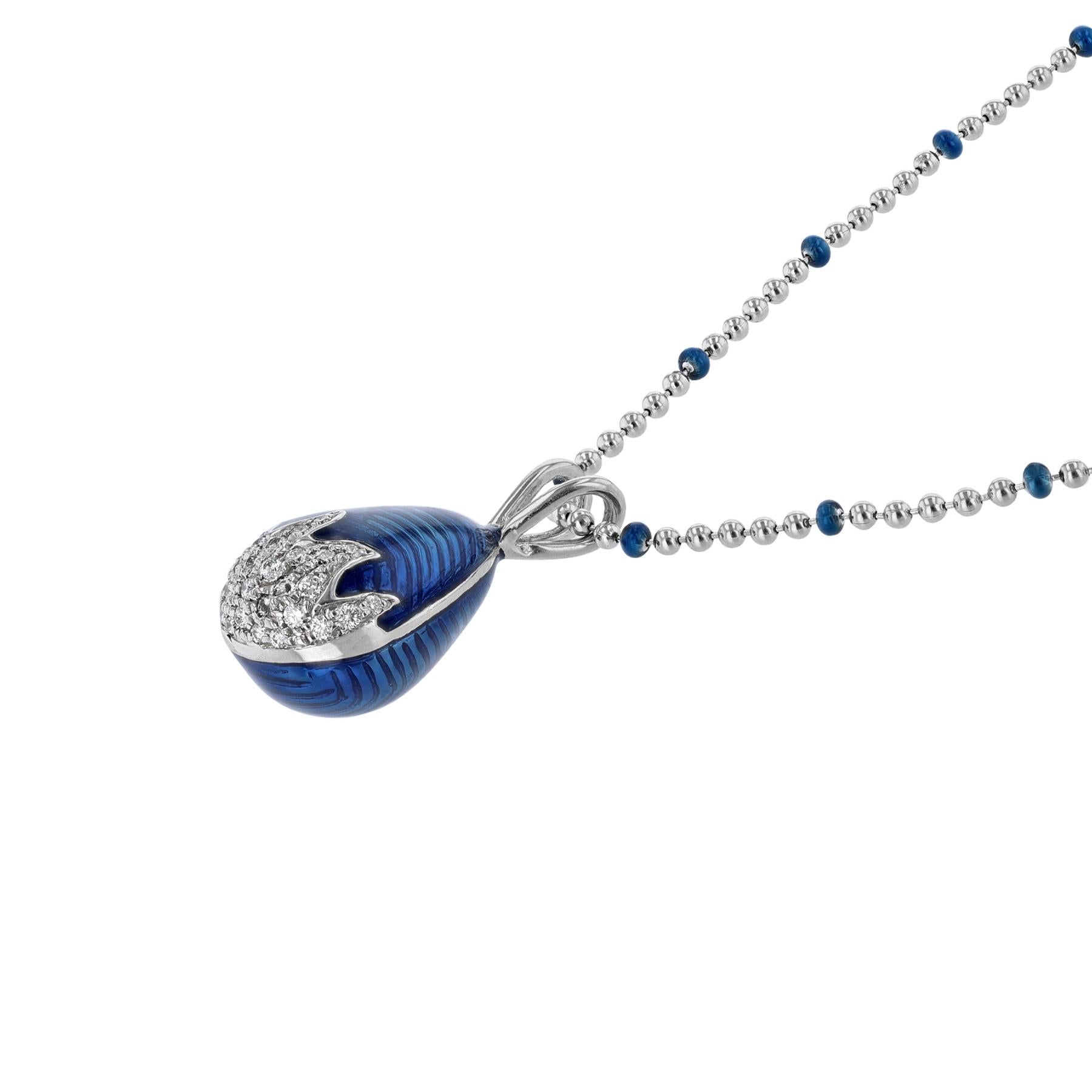 This necklace is made in 18K white gold and blue enamel. It features an egg pendant with 0.29 carat diamonds.