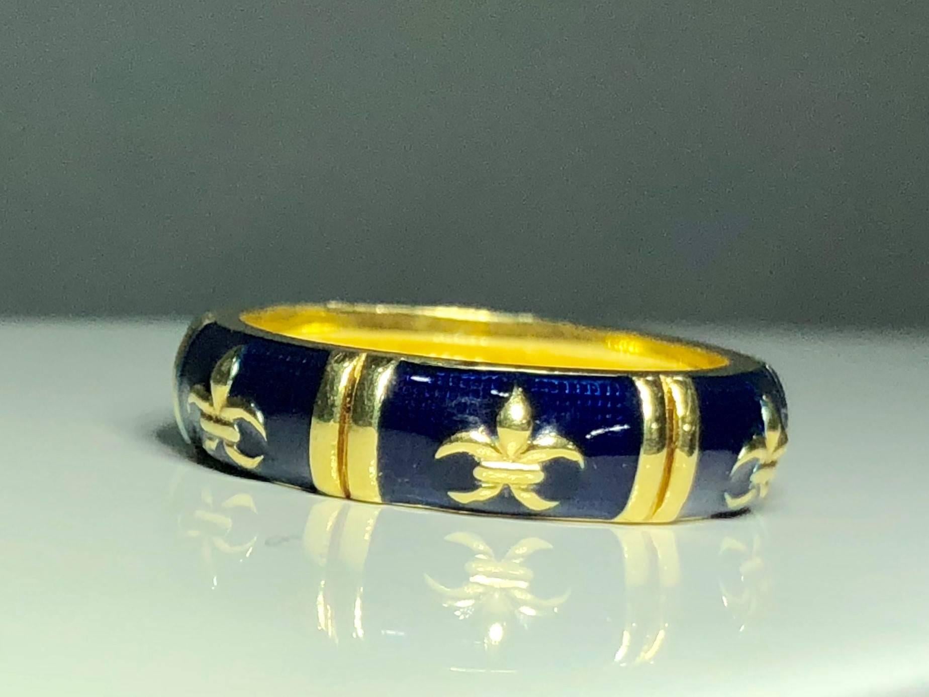 Hidalgo 18 karat yellow gold and enamel Fleur De Lys stackable band ring. This Hidalgo piece is created in 18 Karat yellow gold, weighing 5.9 grams and 3.9 dwt.. The pattern of Fleur De Lys repeats around the ring. A beautiful dark navy blue enamel