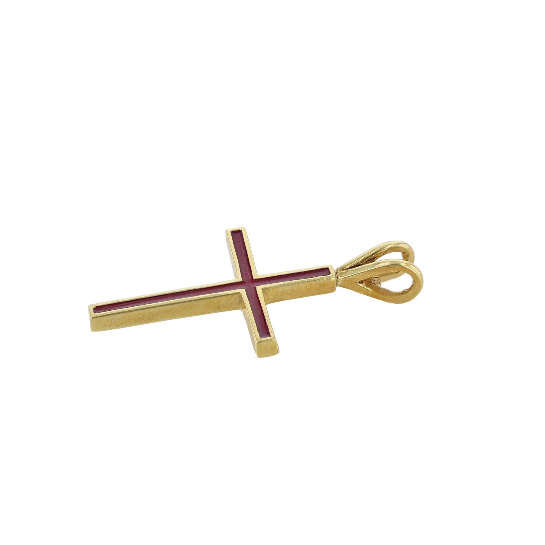 This cross pendant is made in 18K yellow gold and red enamel. 