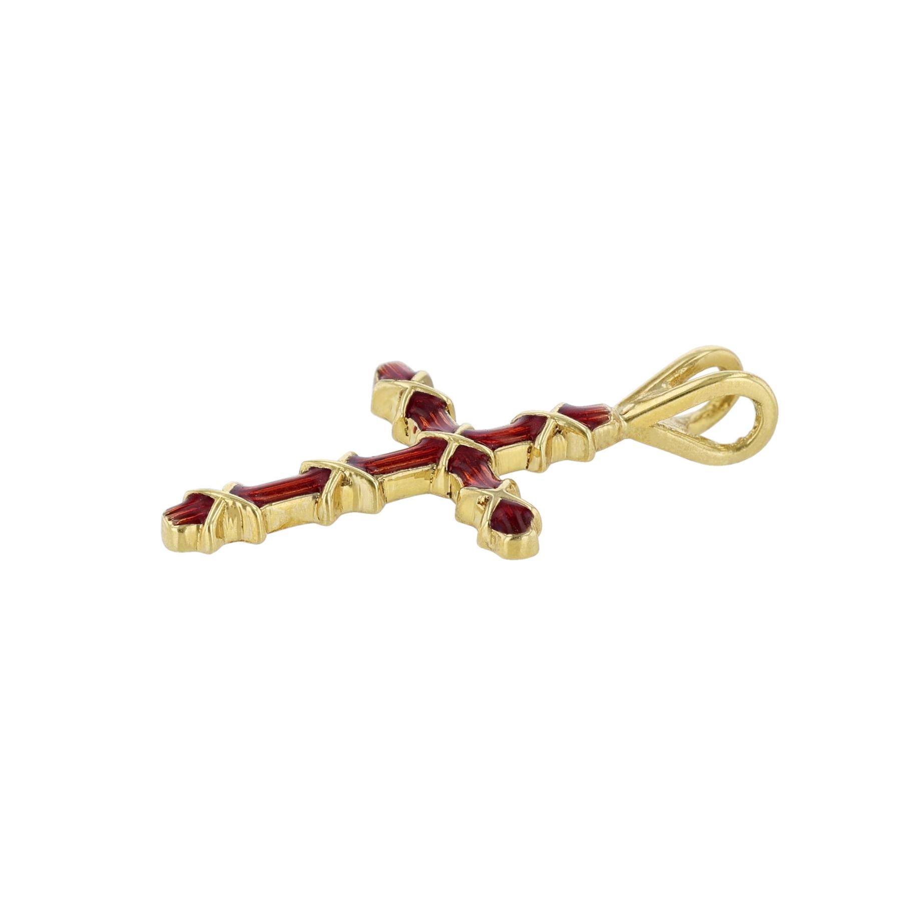 This cross pendant is made in 18K yellow gold and red enamel. 