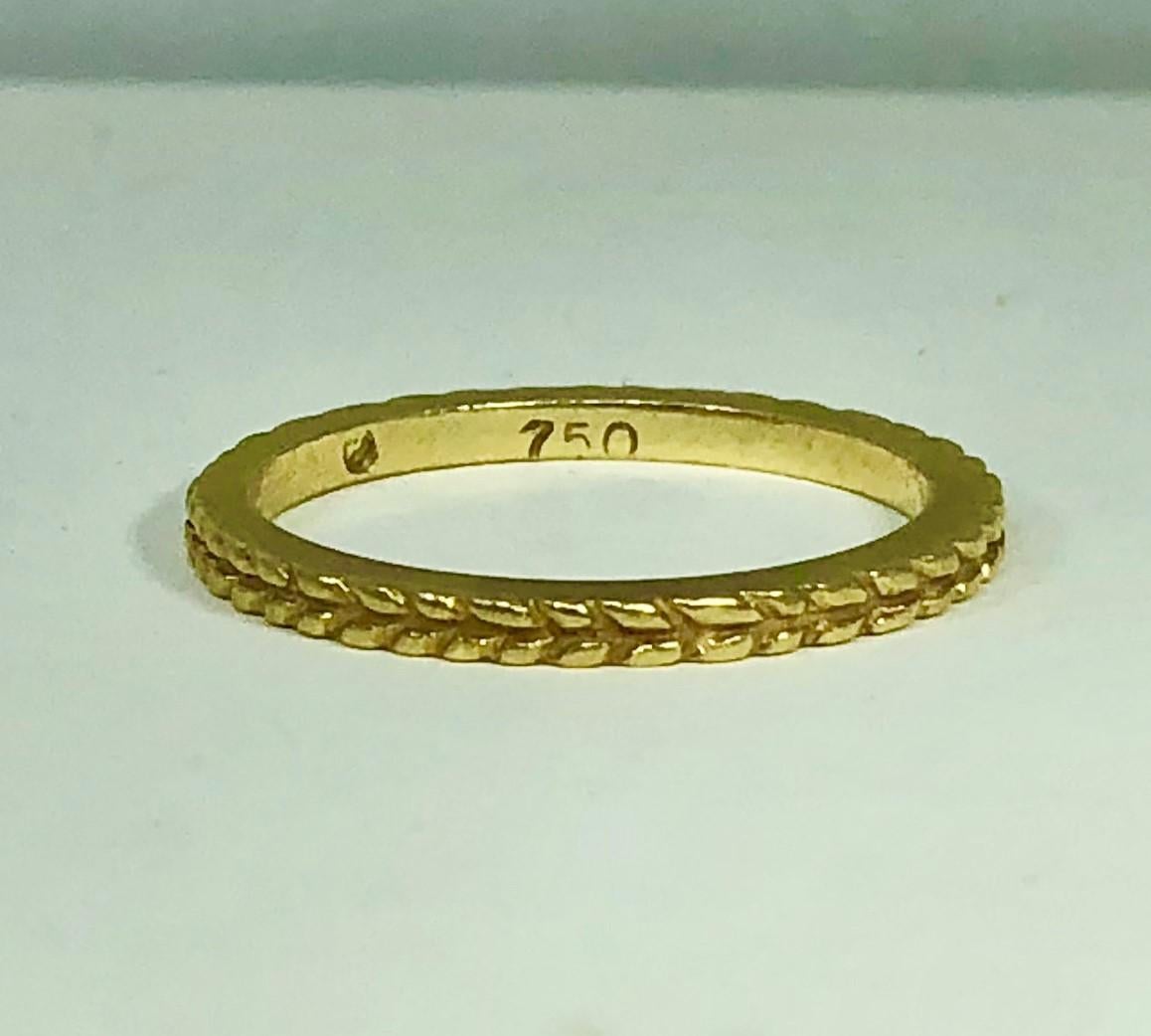 Hidalgo 18 karat yellow gold wheat pattern stackable band. Beautiful Hidalgo classic created in 18 karat yellow gold with a knotted wheat pattern texture. This band weighs 2.6 grams, 1.6 mm tall and 2 mm wide. Finger size 6 1/2. This piece can be