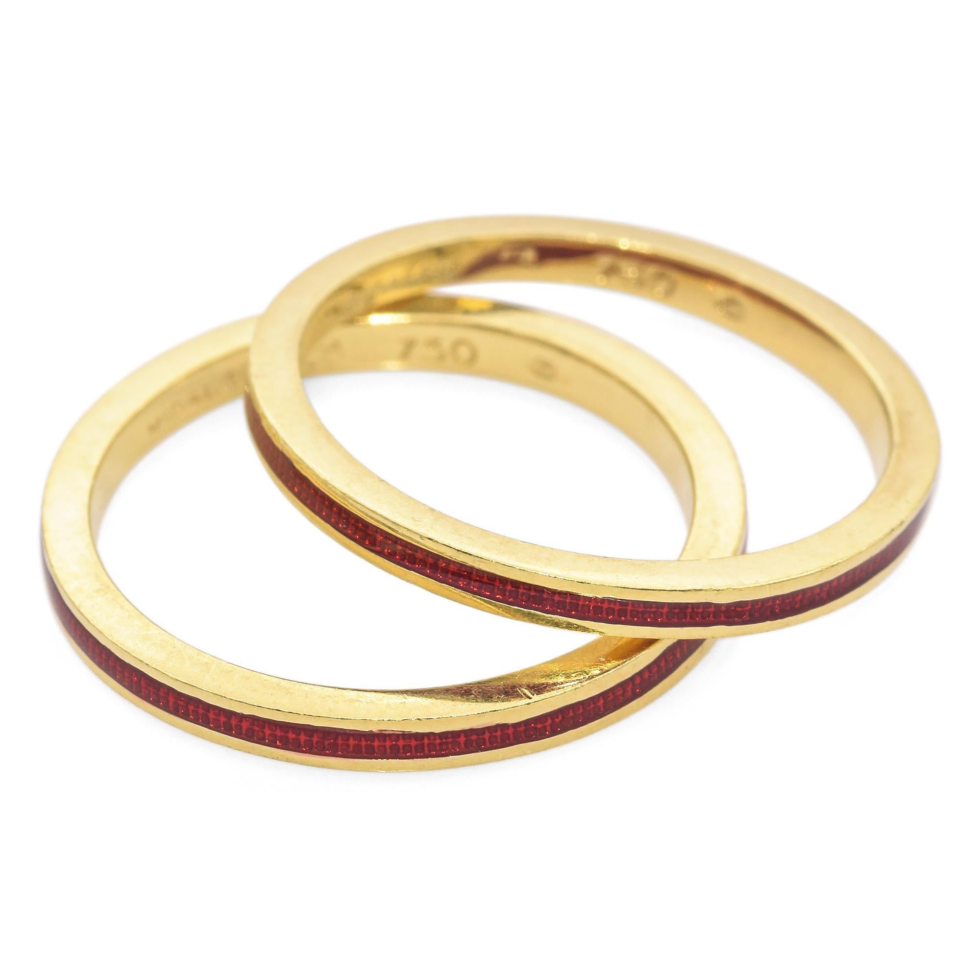 Elegant Gold and Red Enamel Stackable Band Rings by Hidalgo. These striking band rings are crafted in gold, featuring vibrant red enamel inlay. Two parallel bands, each adorned with a textured red enamel strip, creates a bold and modern look. The
