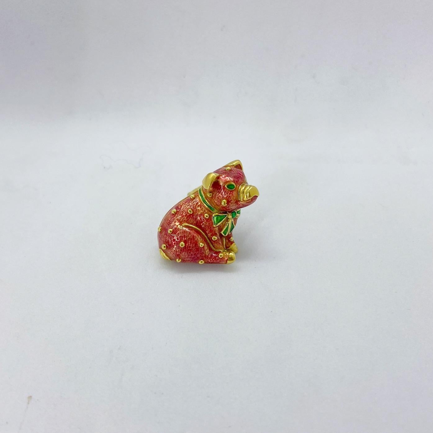 This 18 karat yellow gold brooch was designed by Hidalgo. The company is most noted for their beautiful enamel work. This adorable pig brooch is the perfect example of their craftsmanship. The pig is enameled in a candy pink color with green accents