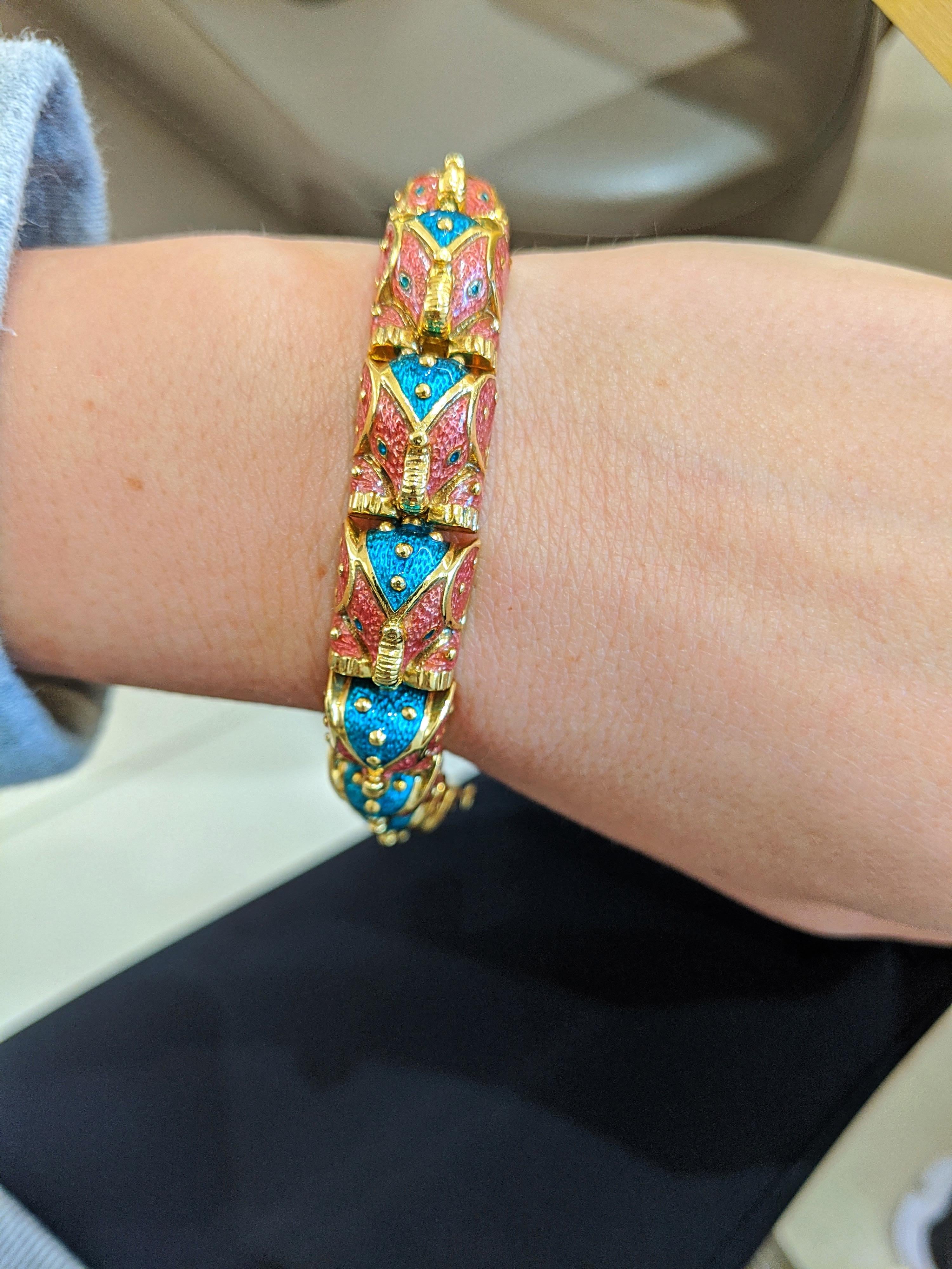 This 18 karat yellow gold bracelet was designed by Hidalgo.  The company is most noted for their beautiful enamel work. This bracelet is crafted with 12 pink and green enameled elephants. Each elephant is an individual link. The bracelet measures 7