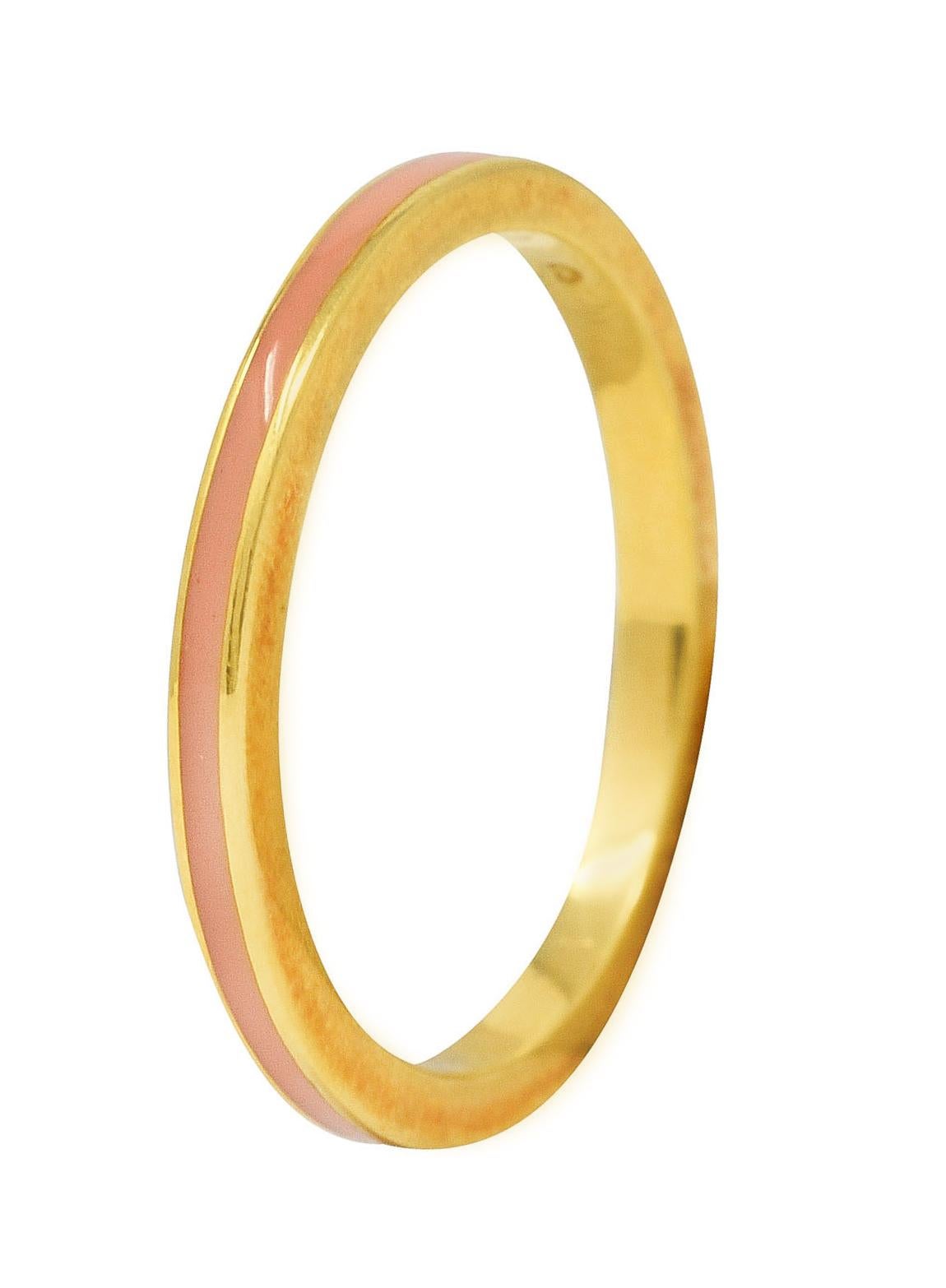 Band ring features a recessed enamel channel fully around. Glossy and opaque light peach in color. With high polished gold surround. Stamped 750 for 18 karat gold. Fully signed with maker's mark for Hidalgo. Circa: 1990's. Ring size: 6 1/2 and not