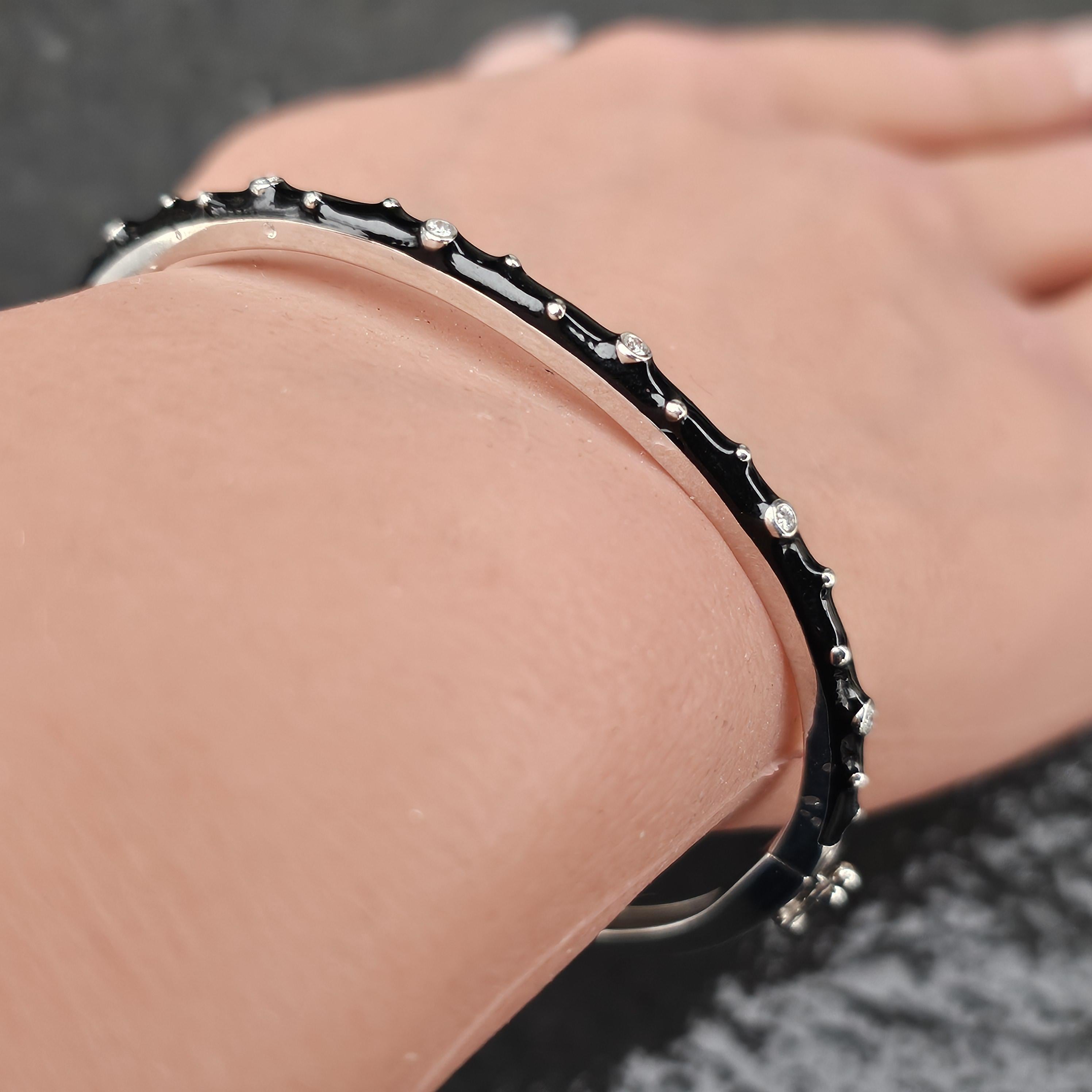 Améliorez votre collection avec cet exquis bracelet bangle Hidalgo. Fabriquée en or blanc 18 carats, cette pièce présente un design élégant avec des diamants blancs ronds sertis en lunette et une finition en émail noir. Le bracelet mesure 6,37