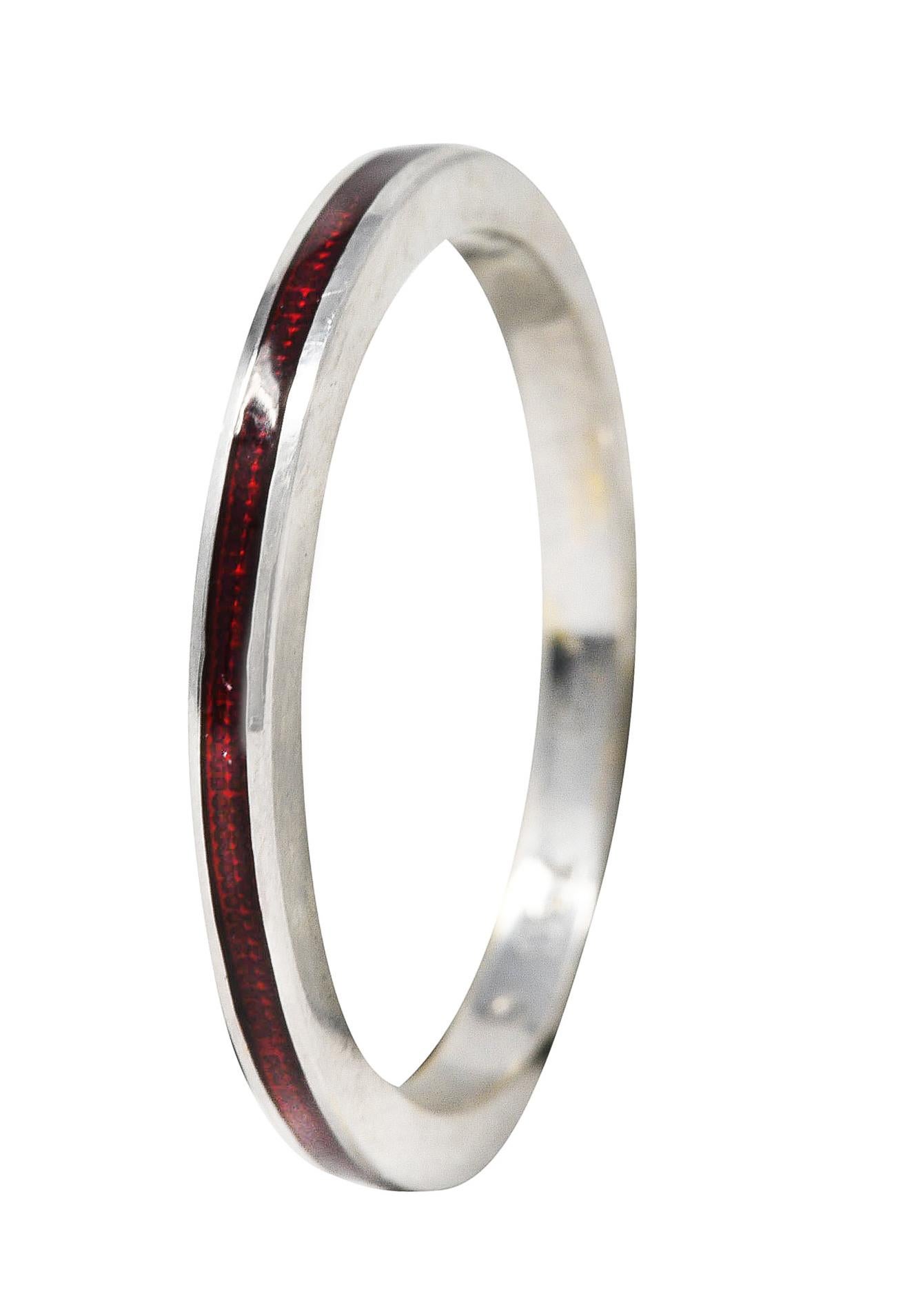 Band ring features a recessed guilloche enamel channel fully around. Transparent medium red in color - glossed over engraved linear pattern. With high polished white gold surround. Stamped 750 for 18 karat gold. Attributed to Hidalgo. Circa: 1990's.