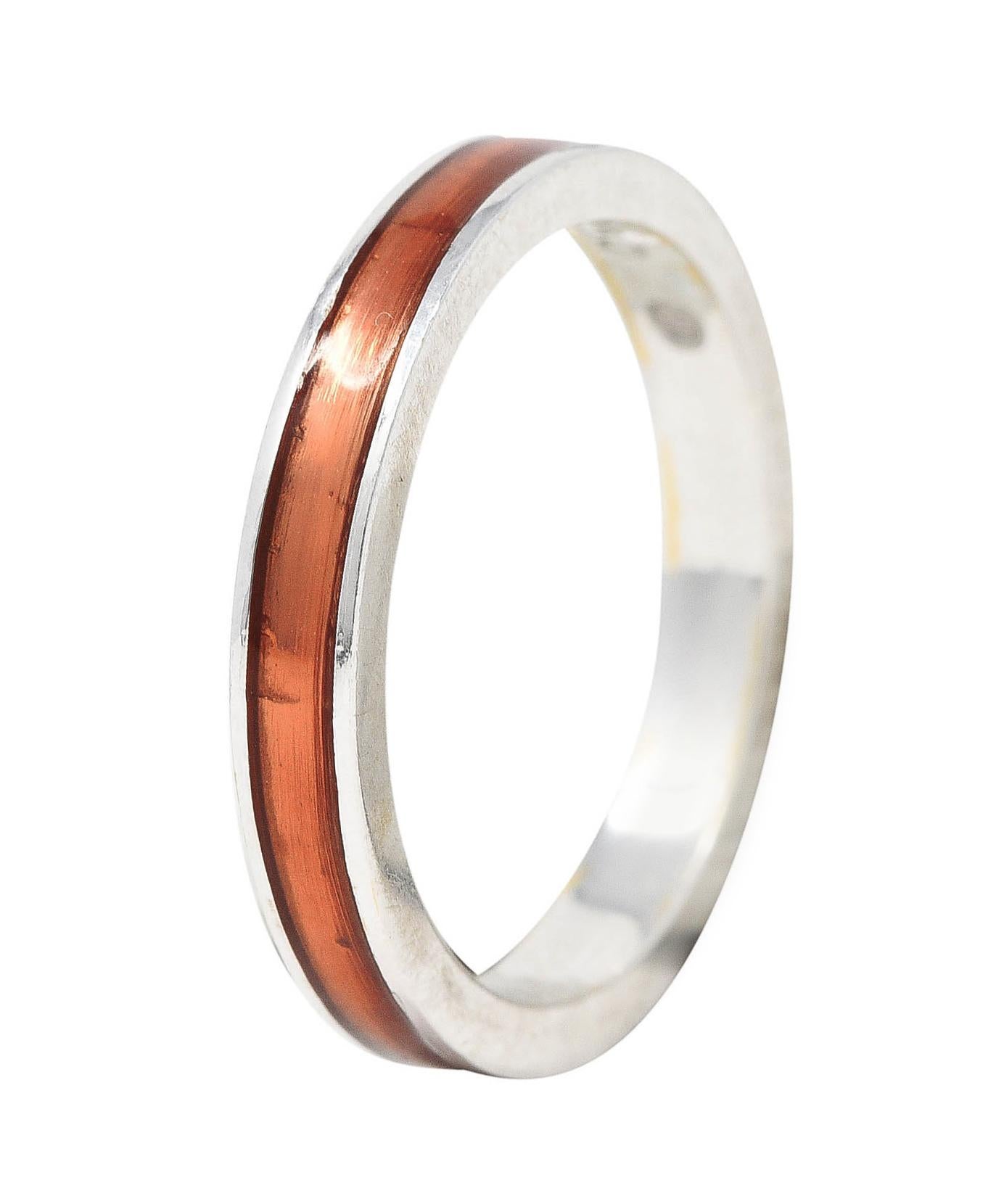 Band ring features a recessed enamel channel fully around. Glossy and transparent light orange in color. With high polished white gold surround. Stamped 750 for 18 karat gold. With maker's mark for Hidalgo. Circa: 1990's. Ring size: 6 1/2 and not