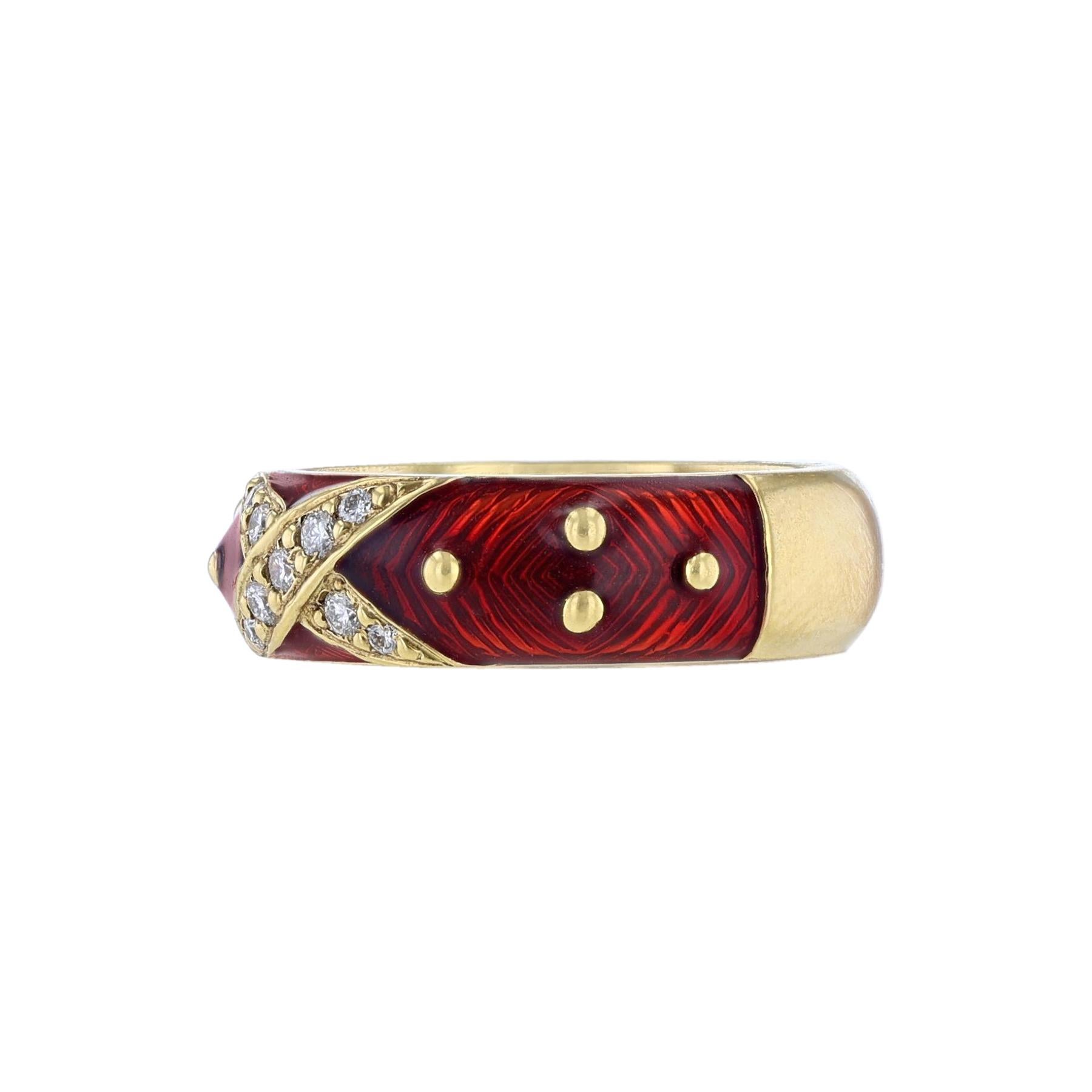 This ring is made in 18K yellow gold and red enamel. It features a center 