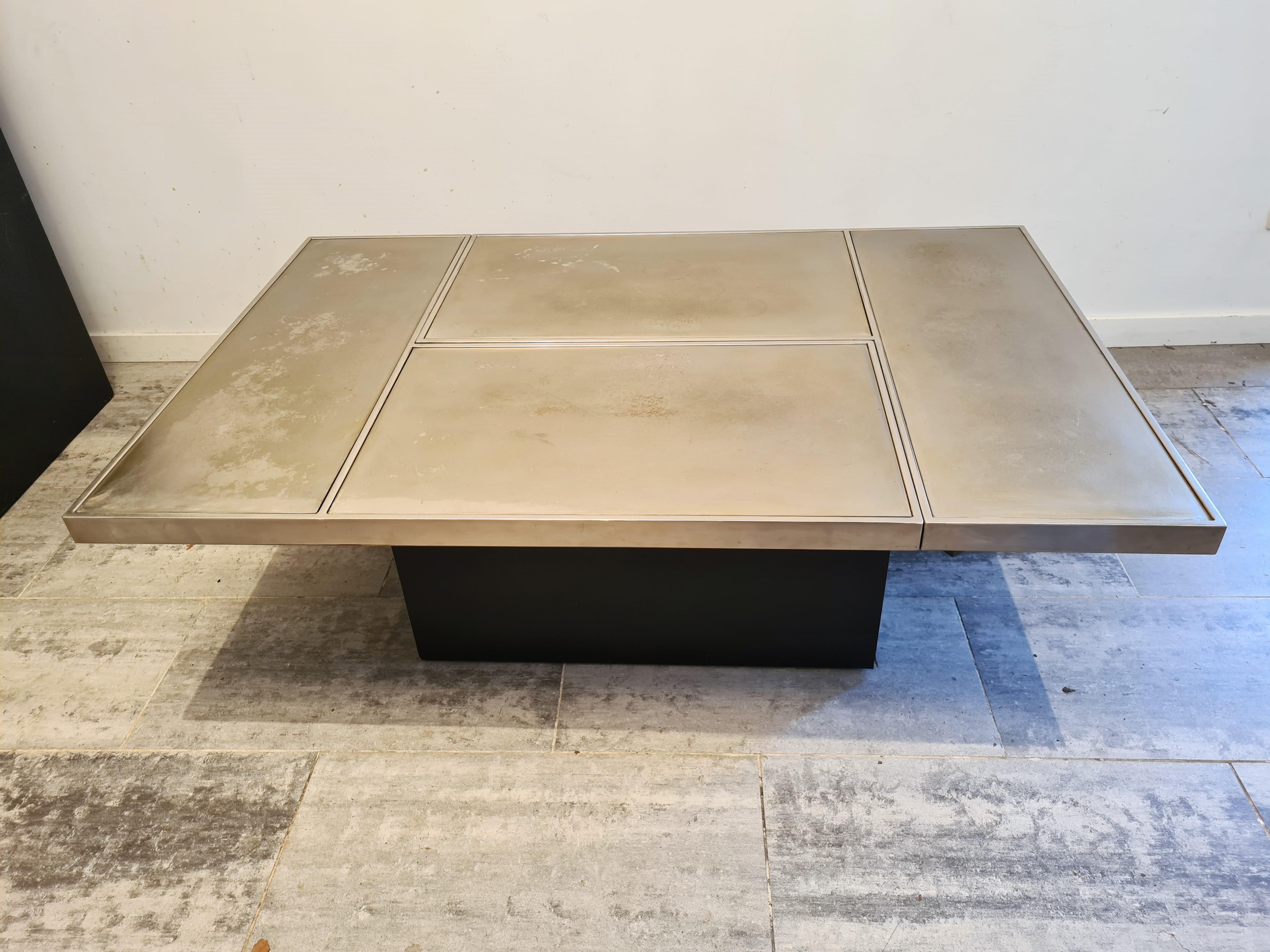Hidden bar coffee table by Willy Rizzo.

This coffee table consists of two brass pivoting parts that open up to showcase a mirrored bar compartment.

Condition: The brass is worn in some spots but still has a good overall look.

1970s -