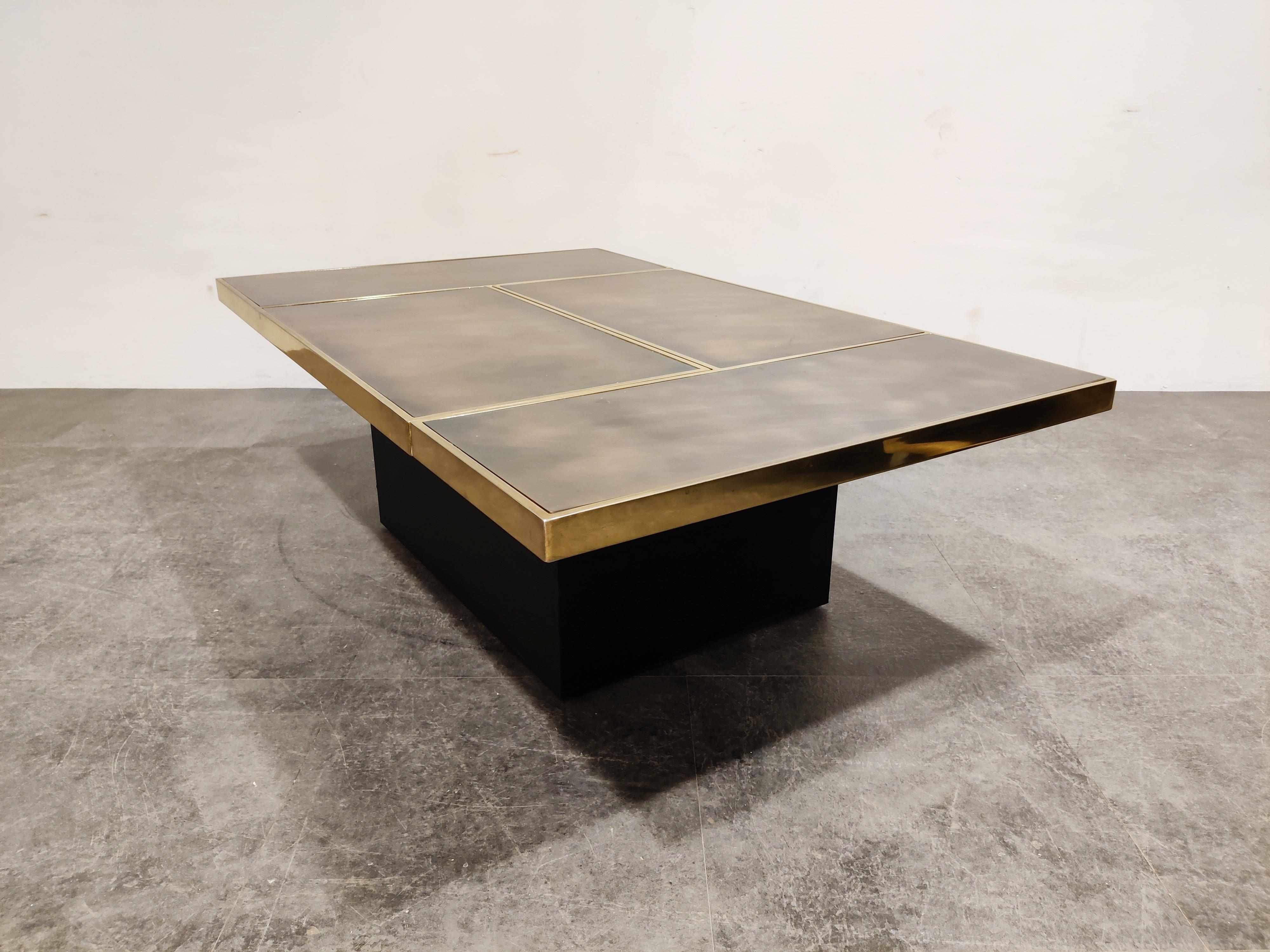 Hidden bar coffee table by Willy Rizzo.

This coffee table consists of two pivoting parts that open up to showcase a mirrored bar compartment.

Brass tables top with inlaid copper plates and a black wooden base.

Good condition.

1970s -