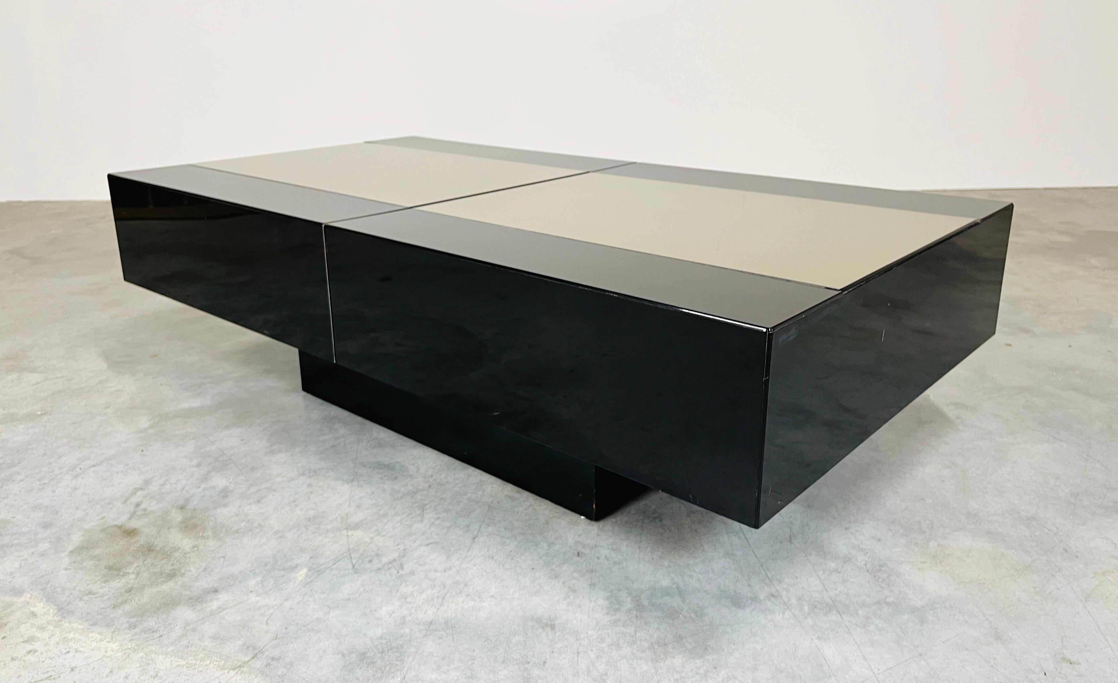 A beautiful multi-functional coffee table that opens up to reveal a hidden dry bar with deep storage for bottles and interior shelf storage for glasses having black lacquer case with light gold mirror center designed by Eric Maville and Jean Claude