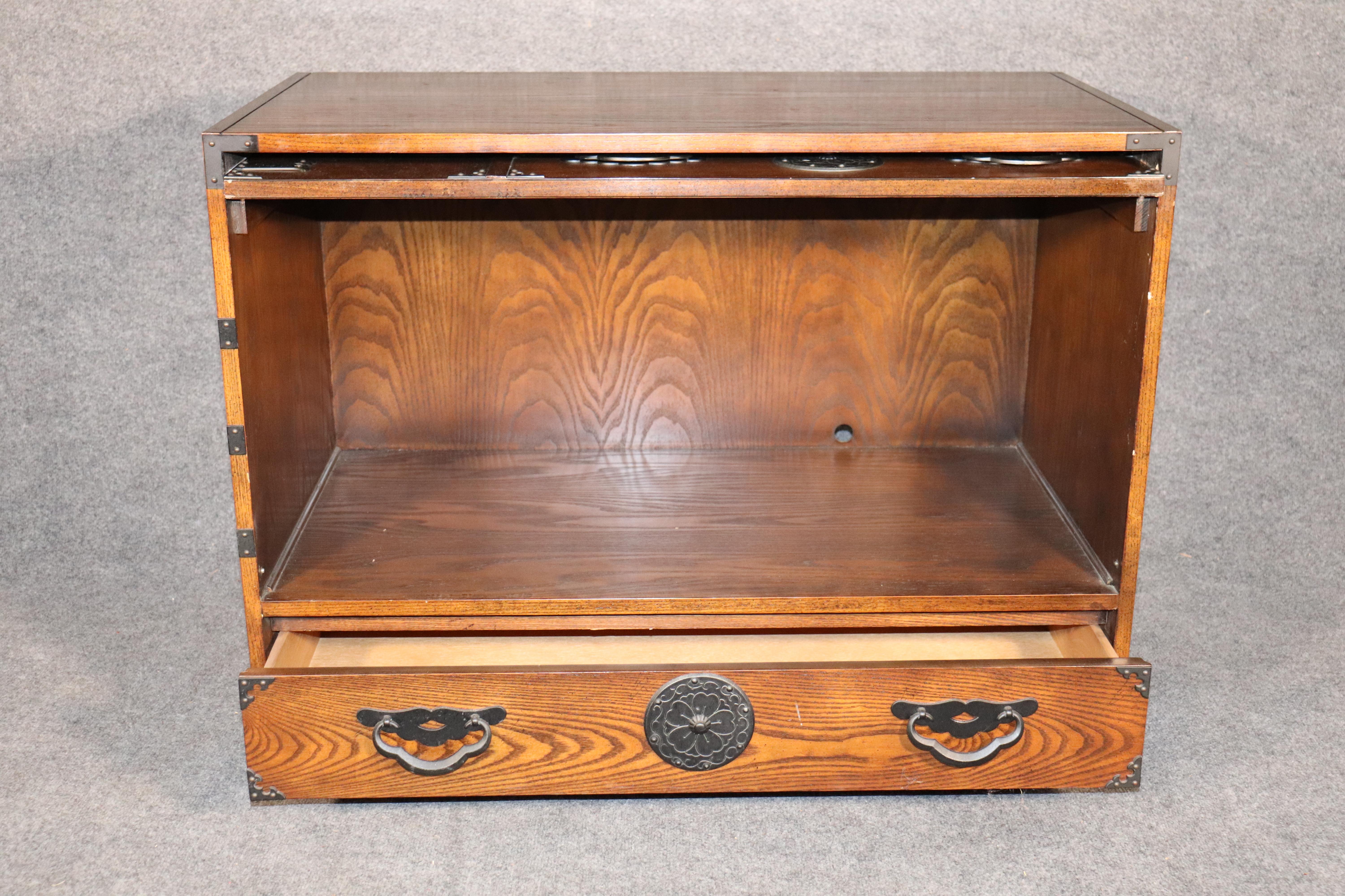 Japanese “Tansu” chest by Baker with inventive cabinet space concealed by a flip up front. Great for TV storage. Adorned with striking iron hardware.
Please confirm location.