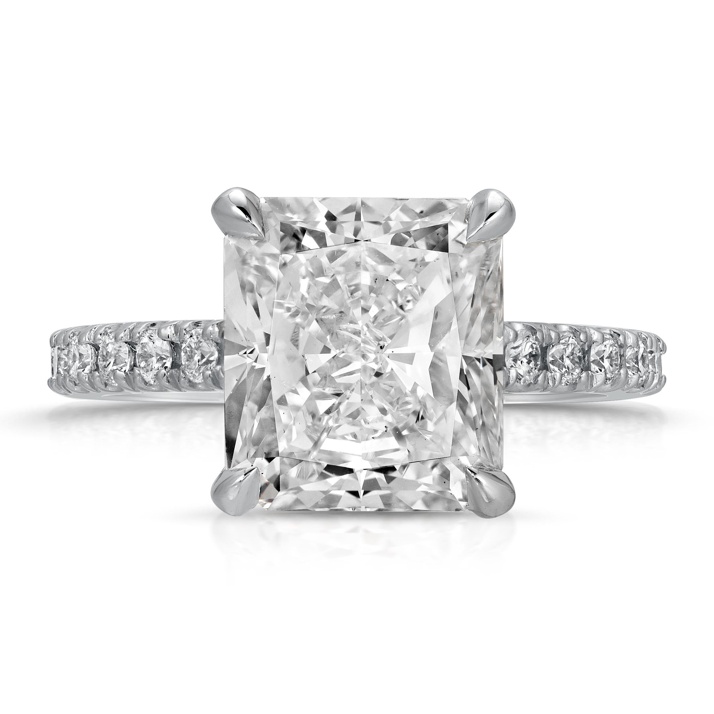 This spectacular Hidden Halo diamond engagement ring will certainly fascinate any jewelry lover. SGL certified 5.02 Carat G/ VS2 Radiant cut center diamond is mounted on a cathedral style four-prong white gold ring. The ring basket and shank are