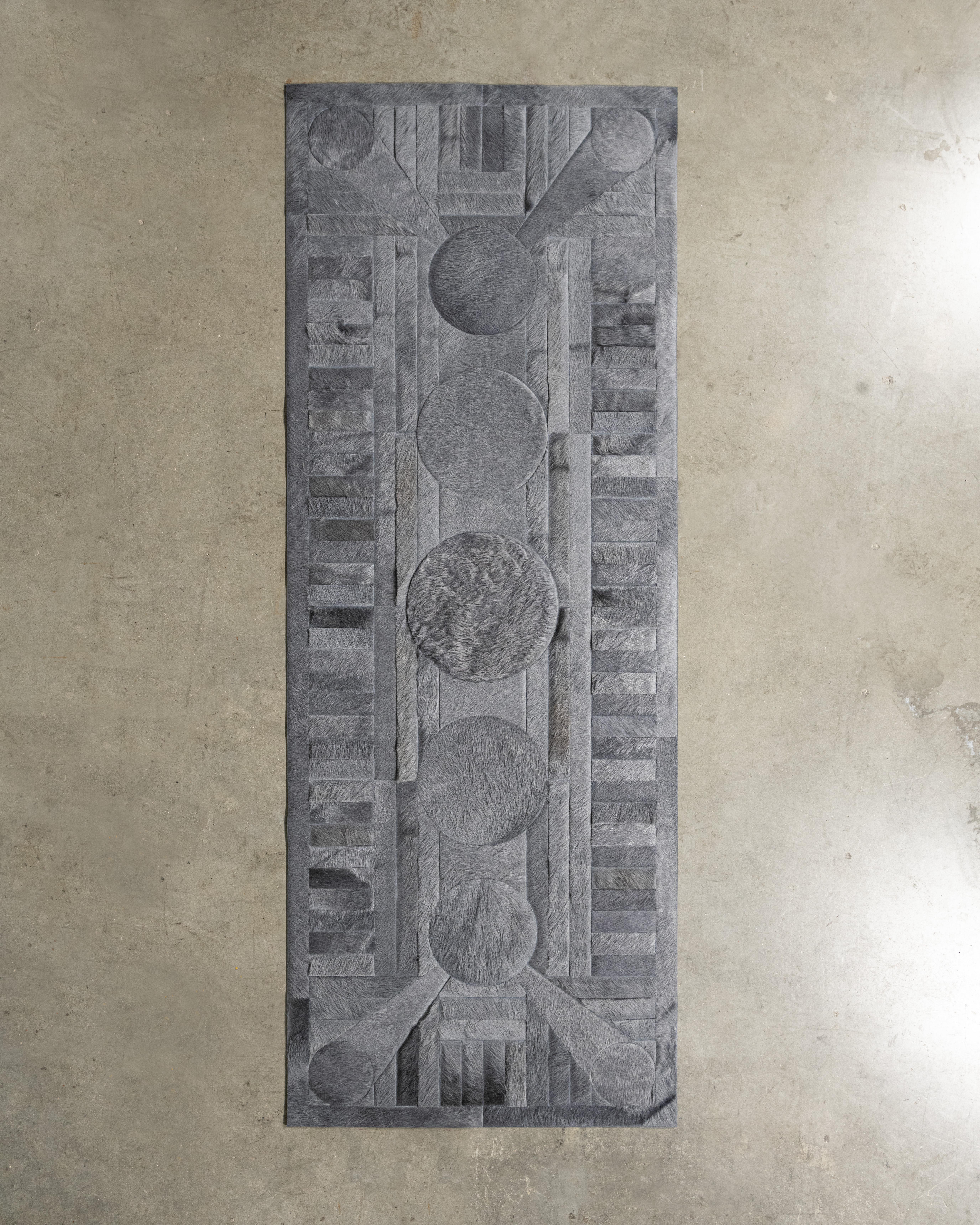 Ce tapis Atlas Hide a été conçu en Collaboration entre Kyle Bunting et le photographe Douglas Friedman.
 

 A propos du Design/One :
 Atlas, une Collectional créée en collaboration avec le photographe Douglas Friedman, est le reflet du terrain vaste
