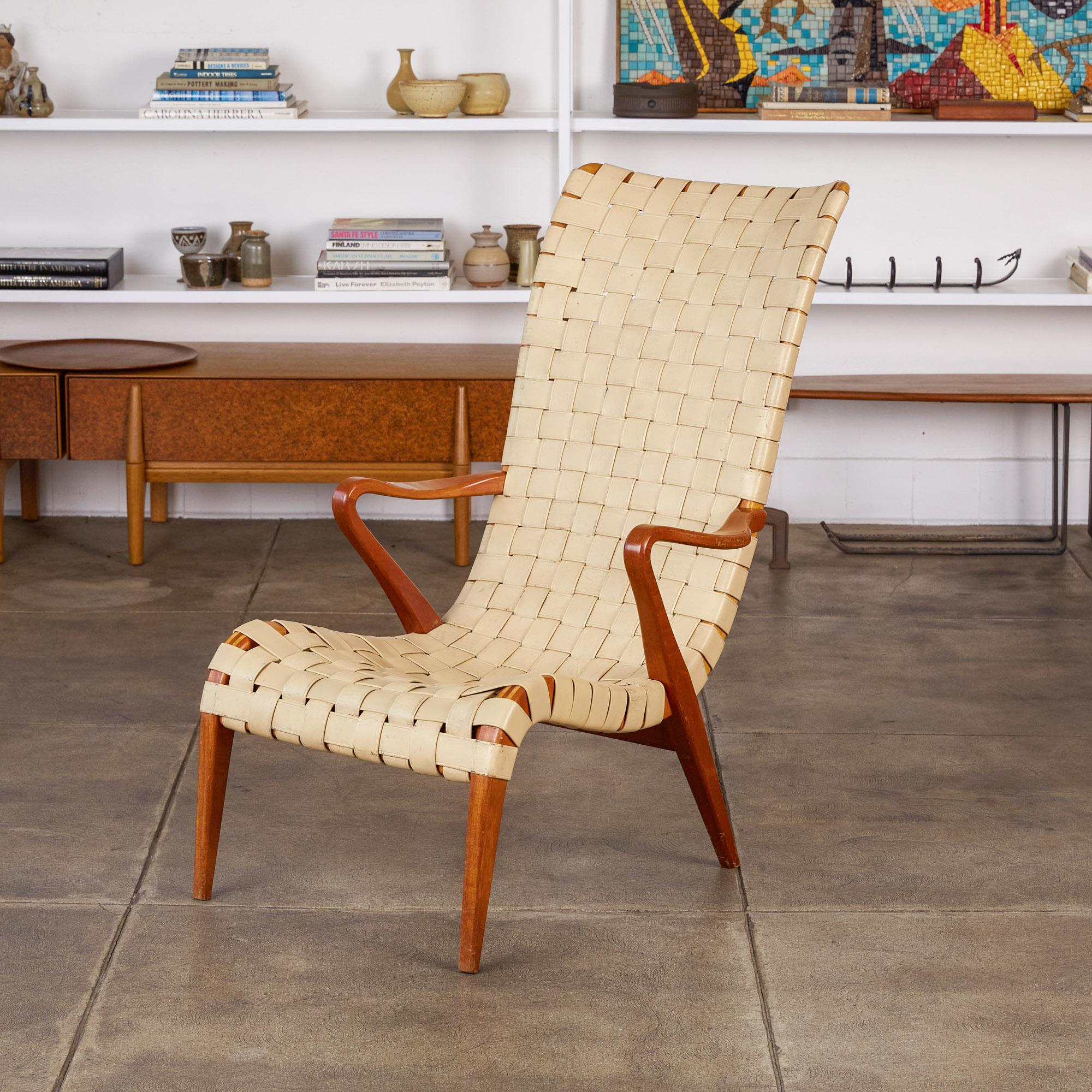 A Pioneer of Swedish Modern, a uniquely functionalist discipline of Scandinavian design, Axel Larsson designed modest living pieces with an eye for blonde or bentwood, and woven surfaces. This high-backed lounge chair, an obvious precursor to the