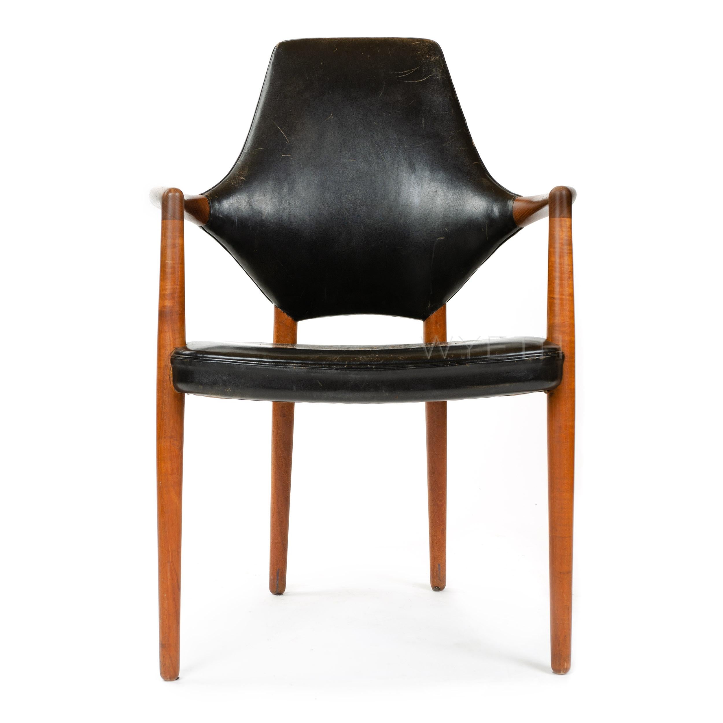 A Scandinavian Modern armchair designed by Helge Vestergaard Jensen. This high back chair features a dynamically shaped back, solid teak wood frame, and is upholstered with black leather. Chair is in original condition with lovely patinated leather.