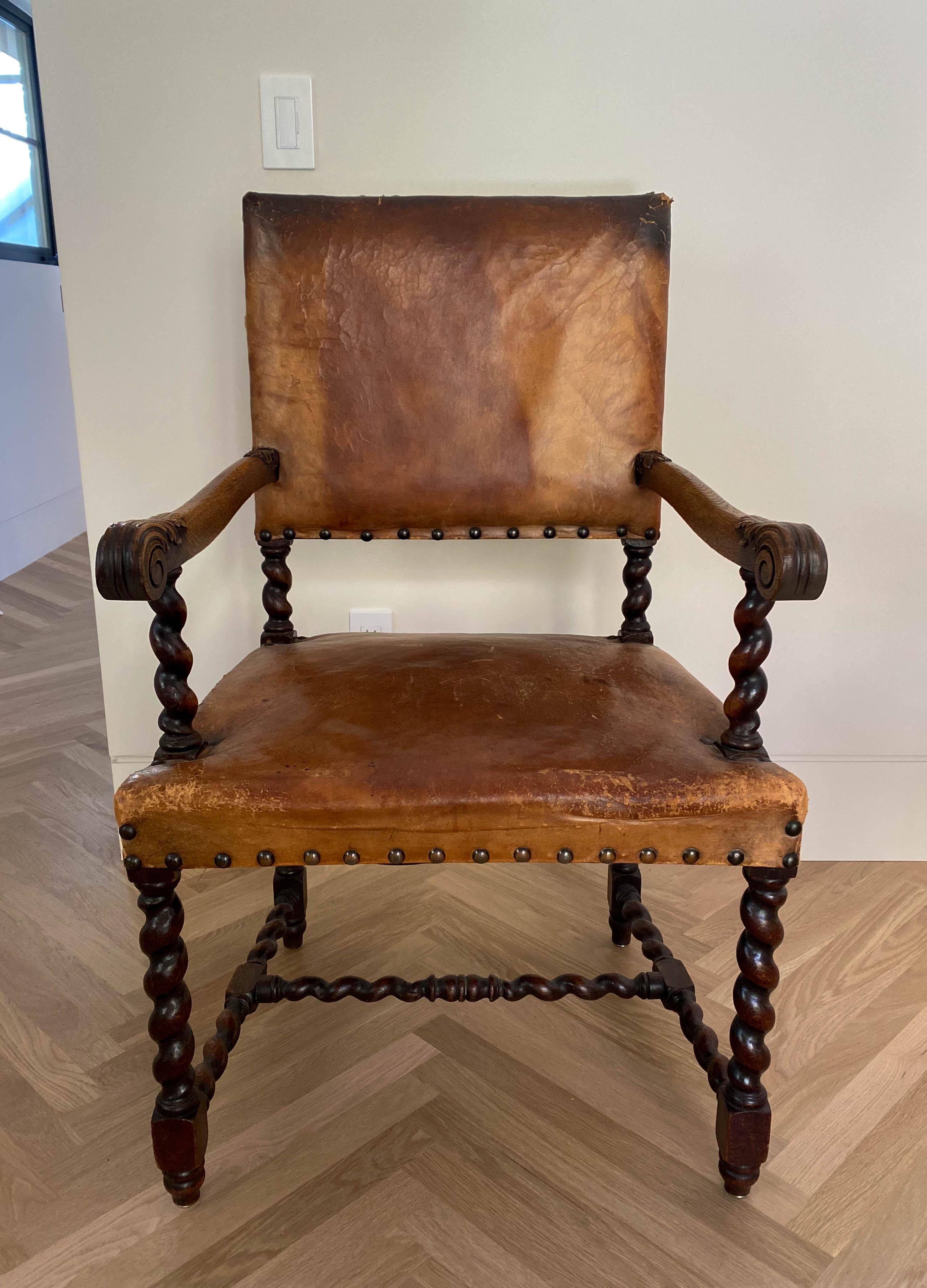 Elegant fauteuil à haut dossier en cuir caramel avec supports de fuseaux en bois sculpté, pieds et accoudoirs en bois d'ébène foncé.