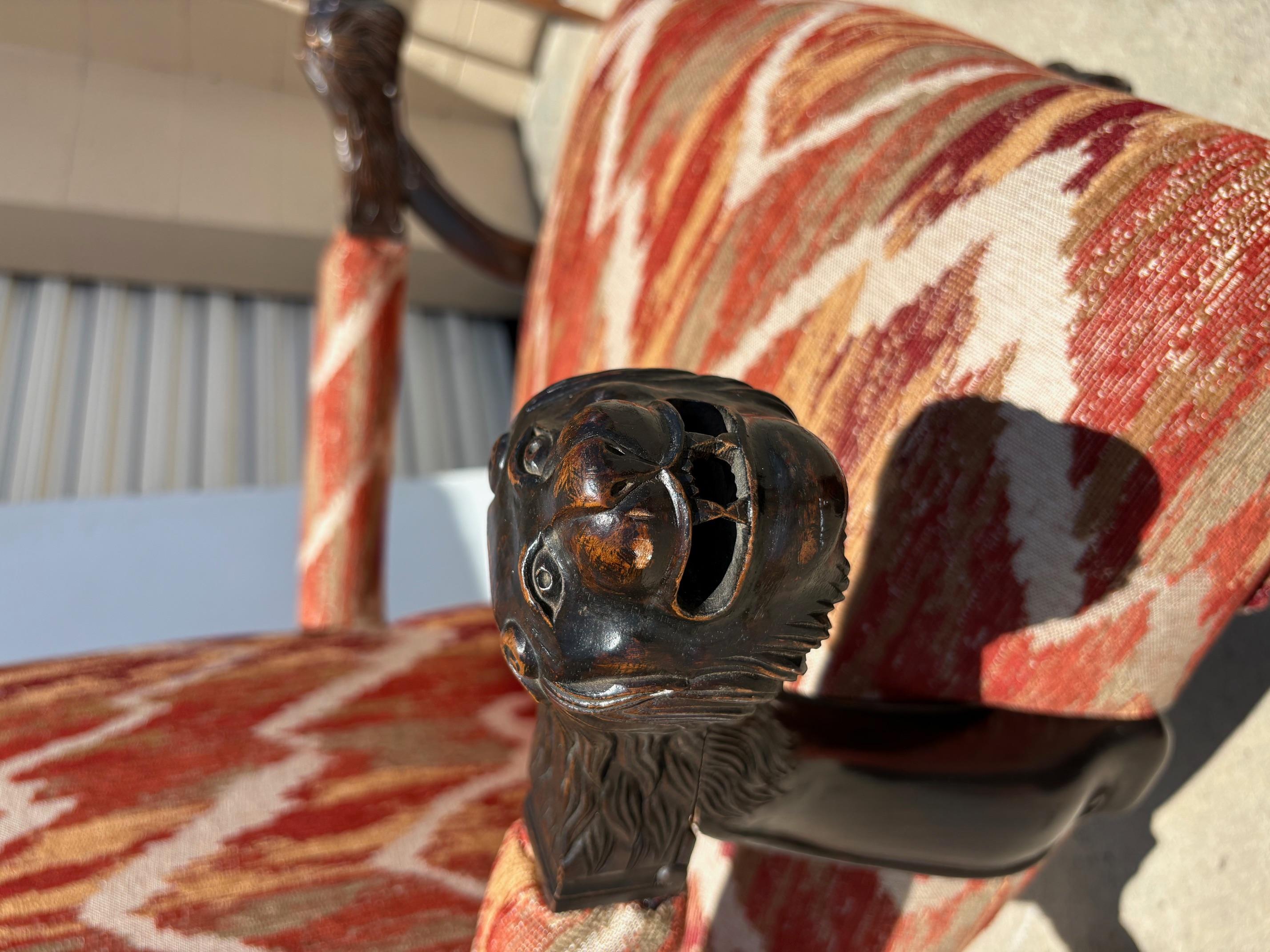 Fauteuil à haut dossier. Les bras sont sculptés, représentant un tigre, et les pieds sont sculptés en griffe. Rembourrage neuf.