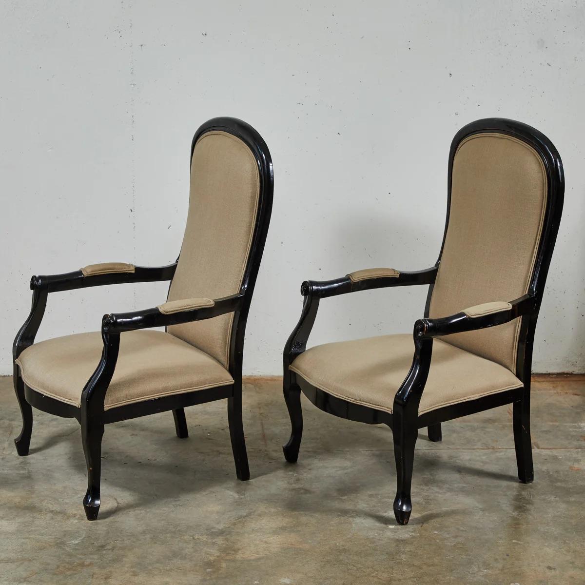 Esta pareja de sillones de madera tallada ebonizada de finales del siglo XIX desprende una elegancia atemporal, que combina a la perfección el diseño clásico con toques modernos. Los marcos de madera oscura y pulida se acentúan con la tapicería de