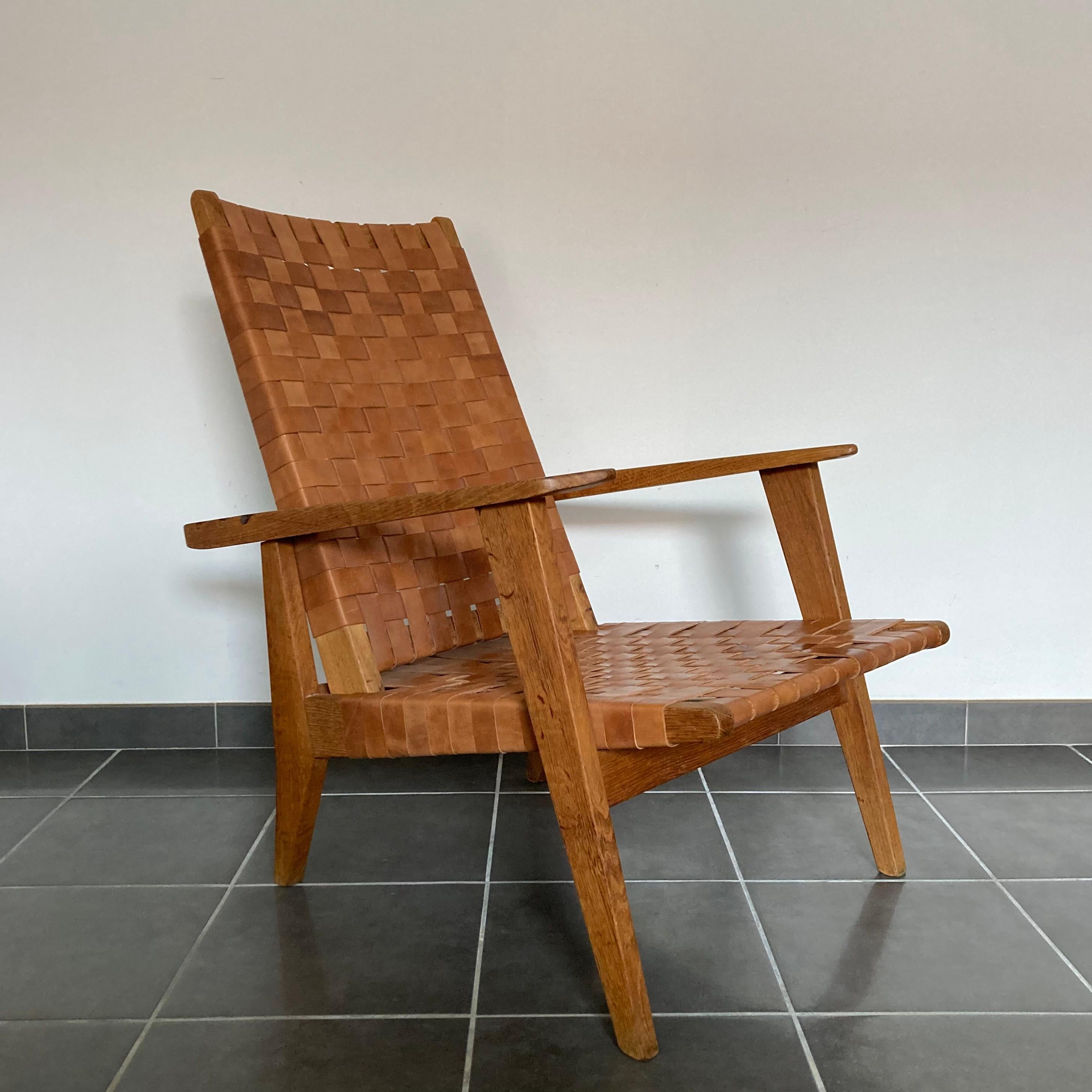 Chaise longue en cuir sanglé et bois de chêne massif.
Fabriqué en France dans les années 1950.

Fauteuil de salon profond avec un haut dossier inclinable confortable. 

Superbe grain de bois et belle patine.