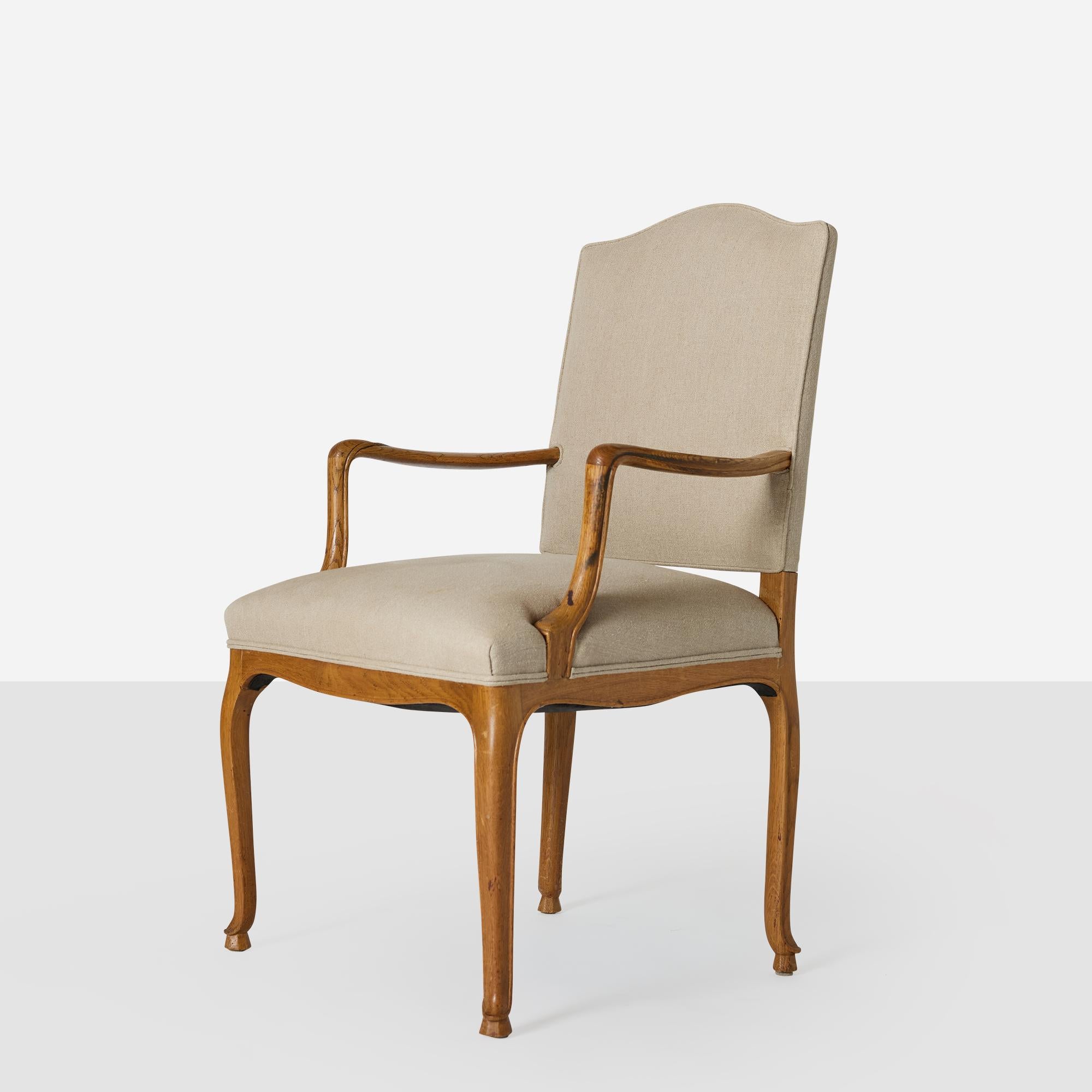 Sillón Frits Henningsen de respaldo alto de roble con bordes perfilados. Silla tapizada con lona de color arena y provista de clavos de latón.