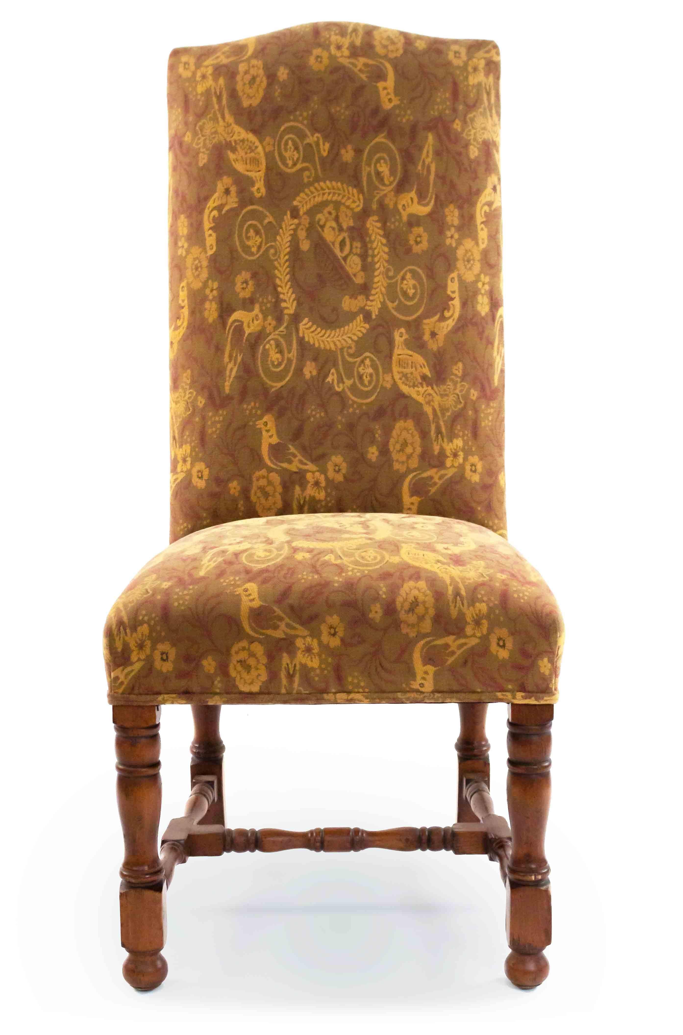 Pair of English Renaissance-style high back dining chairs with floral gold and beige upholstery with a swirling bird motif. Wooden turned legs and stretcher on small bun feet.