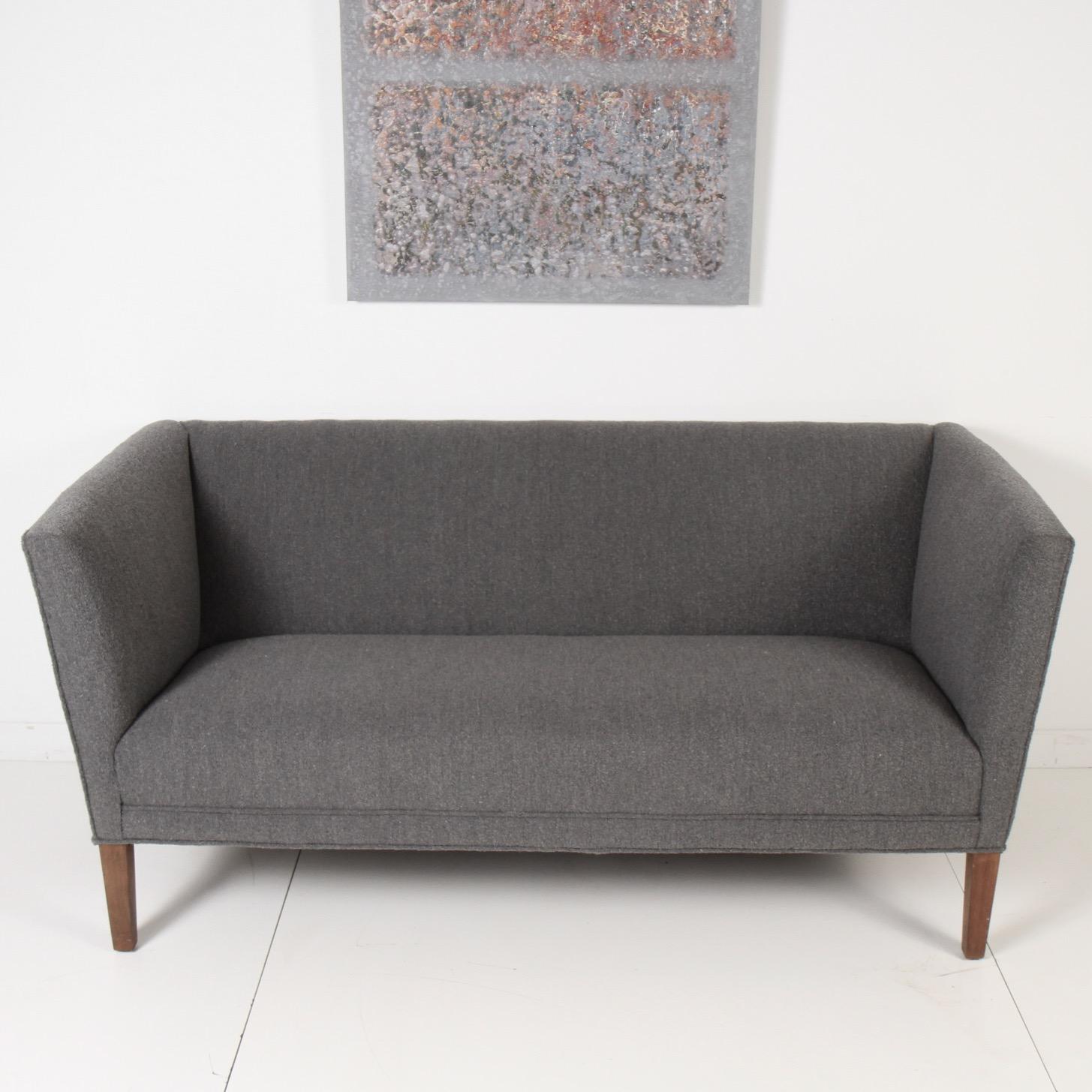 An early Grete Jalk high back settee on walnut legs upholstered in medium grey bouclé´. Made in 1950s Denmark by Johannes Hansen. 

In 1953, Jalk opened her own design studio. Inspired by Alvar Aalto's laminated bent-plywood furniture and Charles