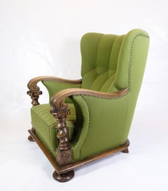 High-backed Armchair in Green fabric with Wood Carvings from 1920s.