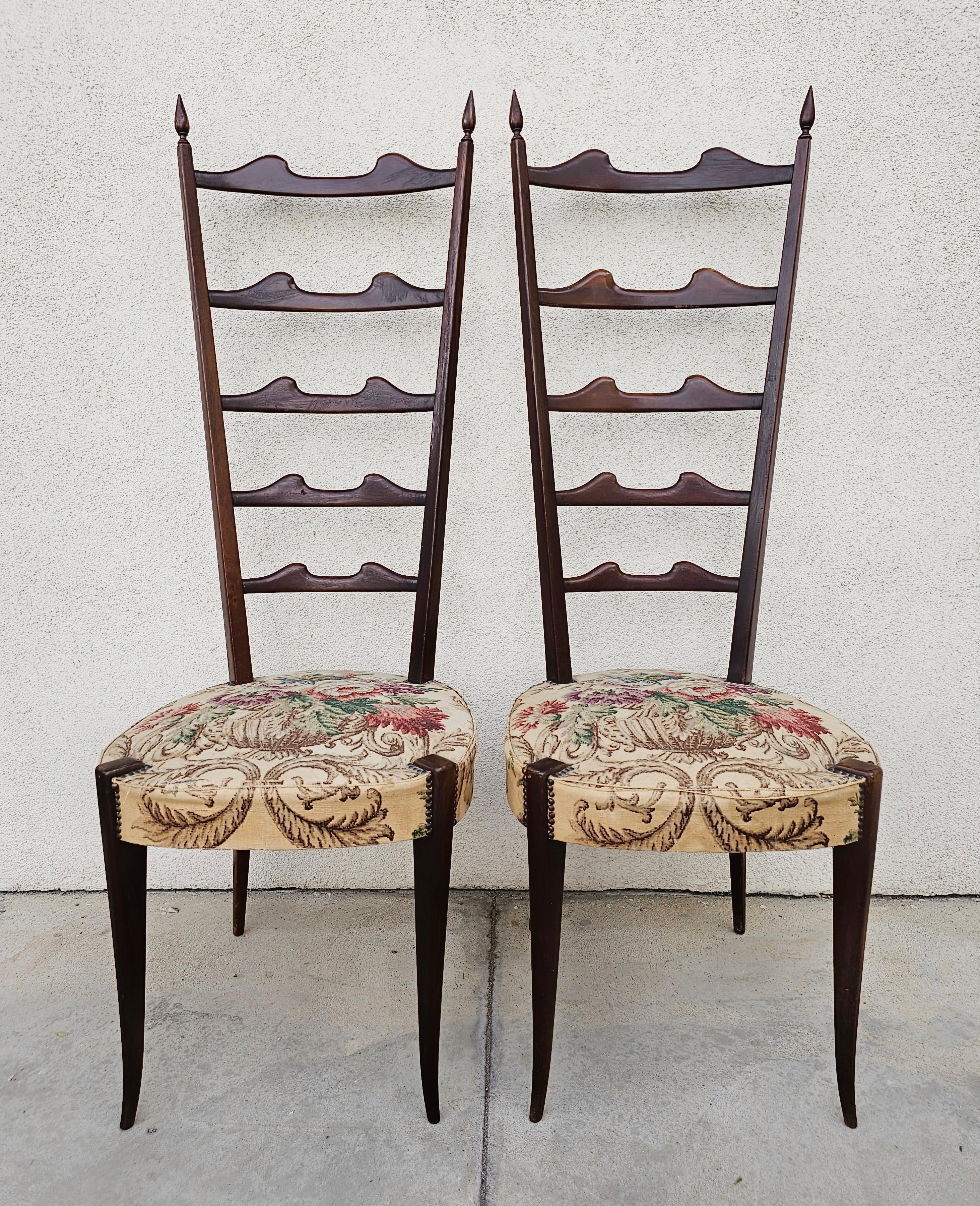 In this listing you will find a pair of Mid Century Modern High Backrest Chairs attr. to Italian star of design, Paolo Buffa. The chairs are done in dark wood, most likely mahogany and upholstered with a floral fabric, which has suffered some