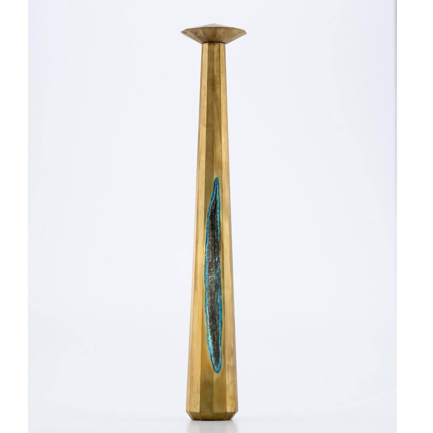 This elegant tall vase has a slender shape, tapering at the top, where another brass component with a circular shape sits. The brass plates used in the making of this piece have been oxidized by hand and shaped using a special technique involving a