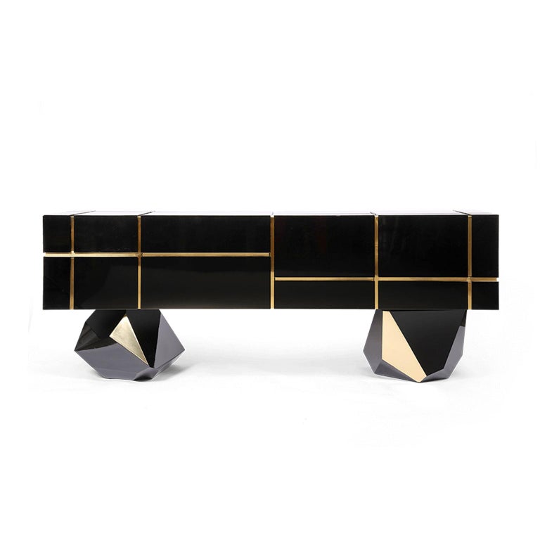 The definition of rich furniture design, this beautiful sideboard is handmade with high-gloss black panels. Luxurious brass pieces bring detail to its base and are referenced by the addition of brass geometrical motifs between drawers. The seven