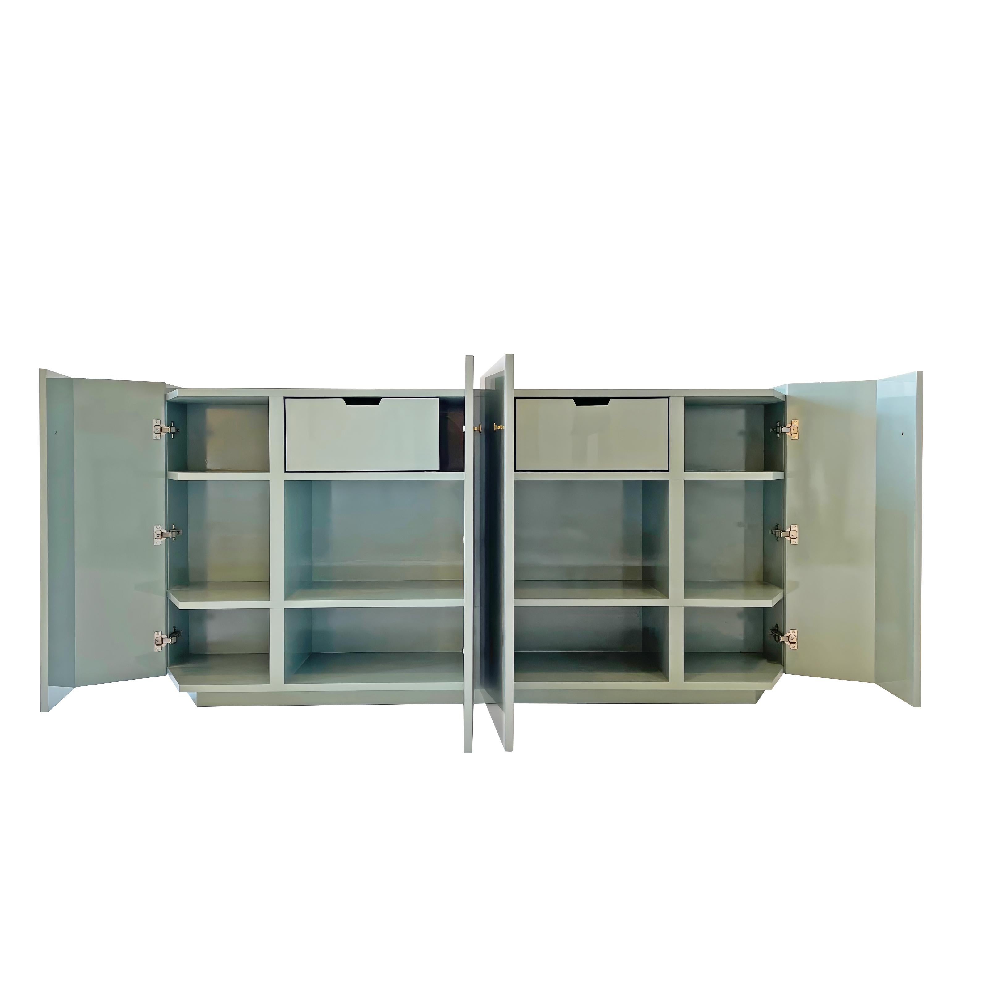 This sleek and highly functional sideboard offers soft close drawers and multiple shelves. With a high gloss Caribbean Teal lacquered finish, this piece  
maximizes storage while maintaining an upscale and modern aesthetic. All four doors feature