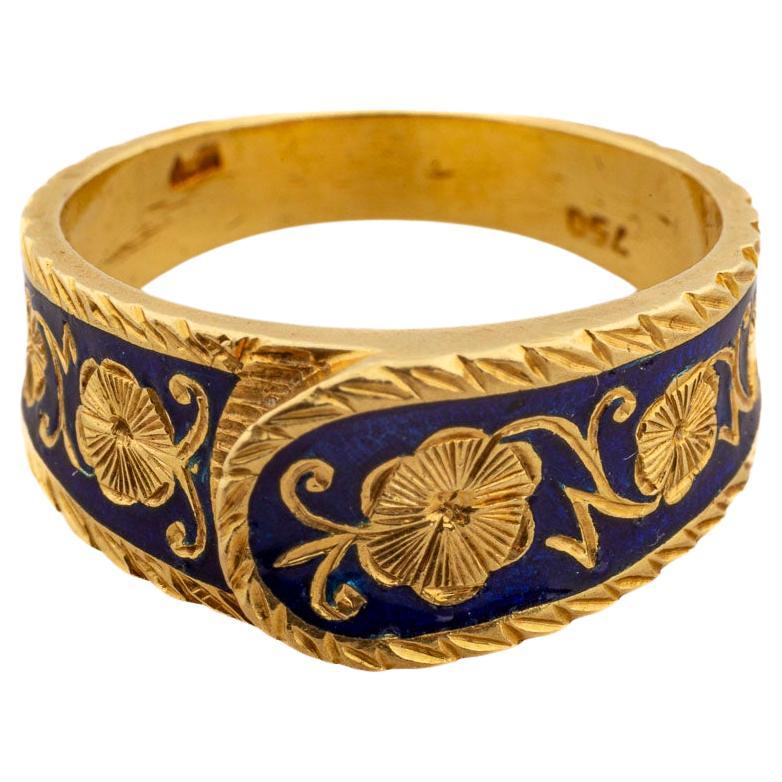 An impactful ring that is exquisite, elegant and timeless though it is a prize for an antique jewelry collector. The ring is scarce. The workmanship is glorious. In 18kt gold,  the fold over band has blue enamel engraved with roses all around. The