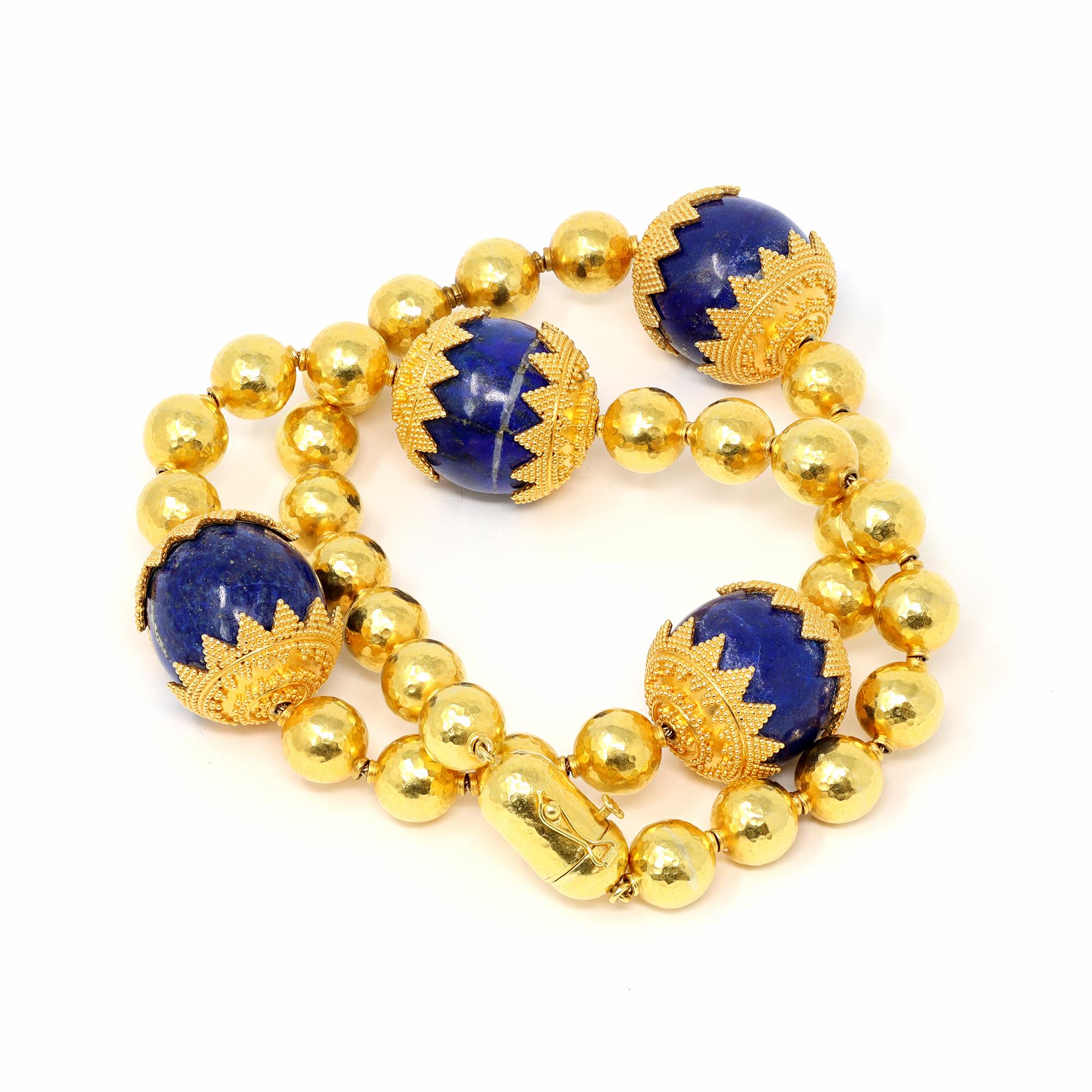 A spectacular Necklace Circa 1970 composed of four lapis lazuli beads capped at each end with milgrain gold work, spaced by  hammered gold beads. The gross weight 144.1 grams with a length of 18 ¾ inches, a width of  ⅞ inch, made in 22 karat and 18