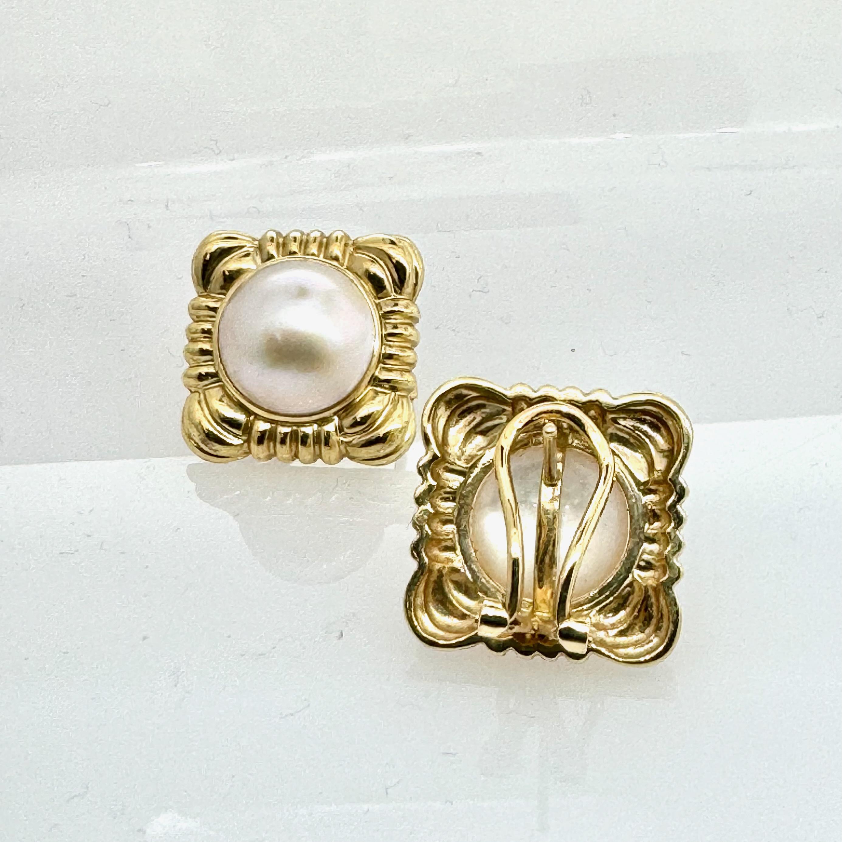 Boucles d'oreilles en perles de Mabe très brillantes dans une monture carrée ornementale.
Fabriqué en Italie, en or jaune de 14 carats, fermeture très sûre à l'aide d'une tige et d'un clip.
La taille de réglage est de 18,2 mm x 18,2 mm.
Le diamètre