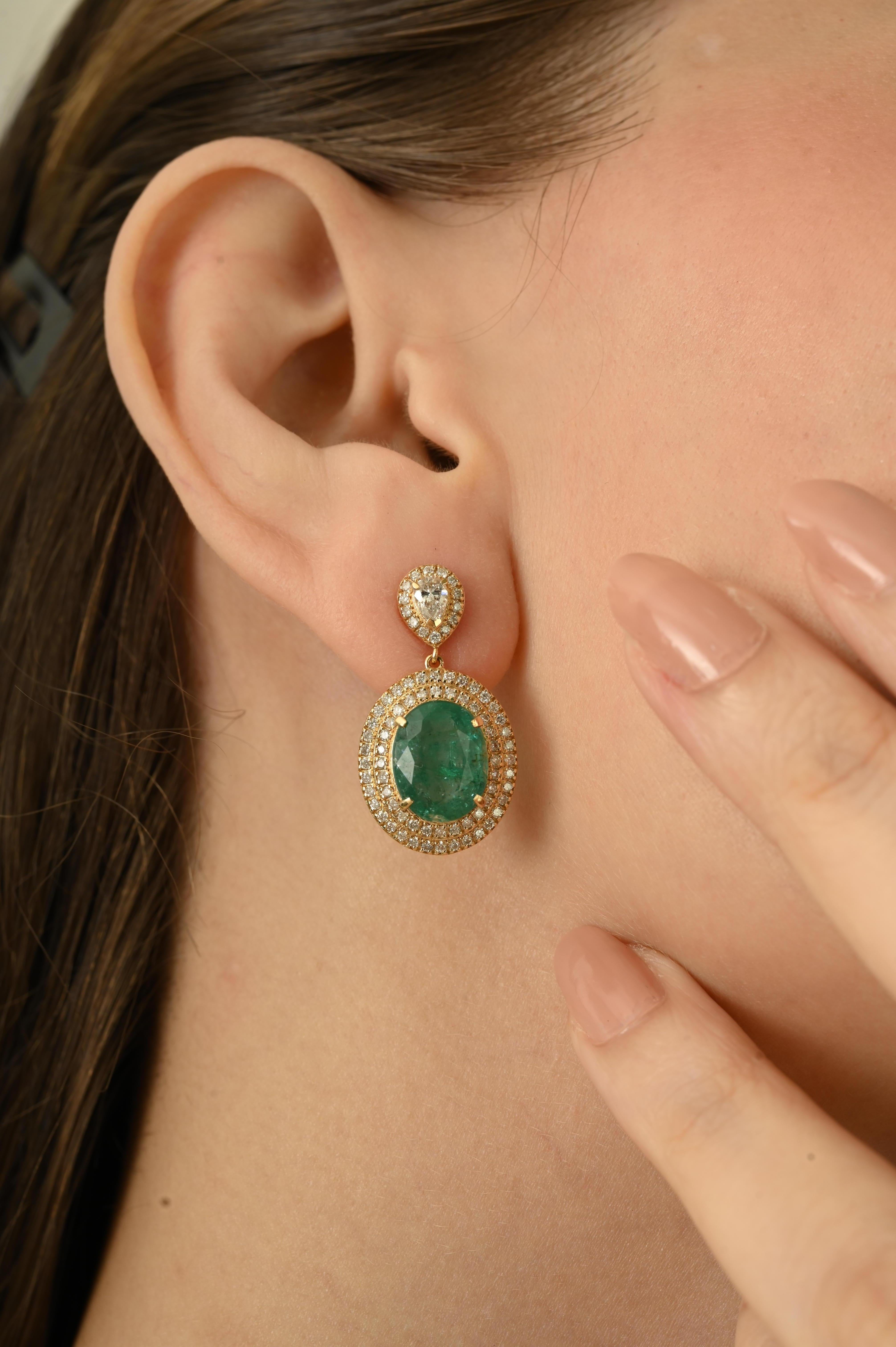 Estos pendientes presentan 7,74 quilates de esmeraldas talla oval como pieza central, acentuadas por 1,42 quilates de diamantes talla redonda y pera. Las esmeraldas están engarzadas con cuatro puntas, rodeadas por un halo doble de diamantes en oro