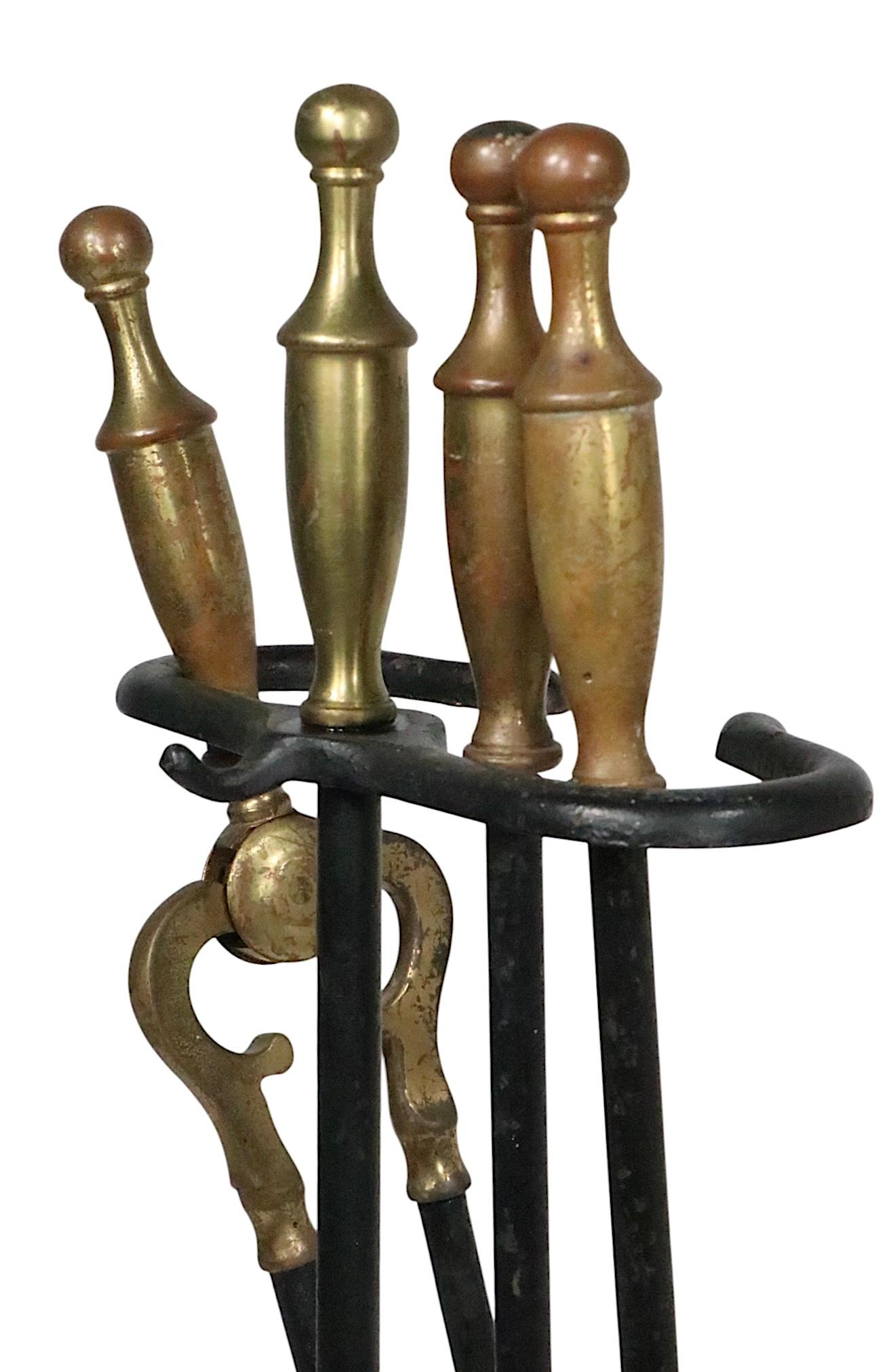 Juego de herramientas para chimenea vintage de 4 piezas de Rostand, bien elaborado, que incluye atizador, pinzas, pala y soporte. El conjunto presenta pesadas asas de latón fundido en forma de remate, y ejes de hierro forjado, etc. Este juego está
