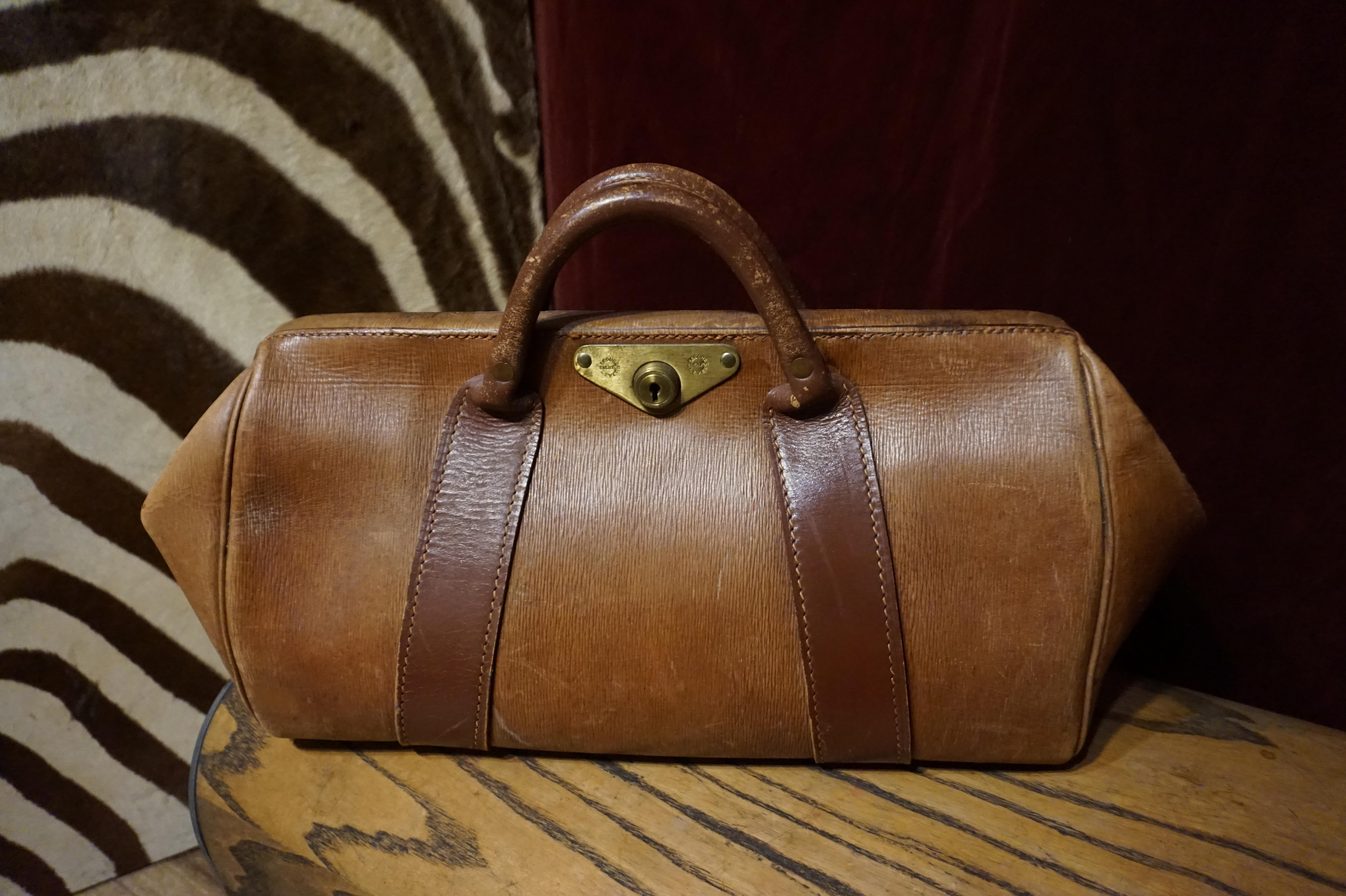 Handsome and original English leather gladstone/weekender bag by Pendragon in good condition. Top notch workmanship and mint condition kid leather inside. Brass hardware and base fittings and attention to detail with elegant form make this a