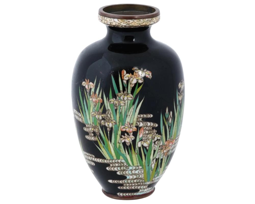 A high quality antique Japanese, late Meiji period, enamel over gilt copper vase. The vase has an urn shaped body and a fluted neck. The ware is enameled with a polychrome image of blossoming flowers on a pond made in the Cloisonne technique. The