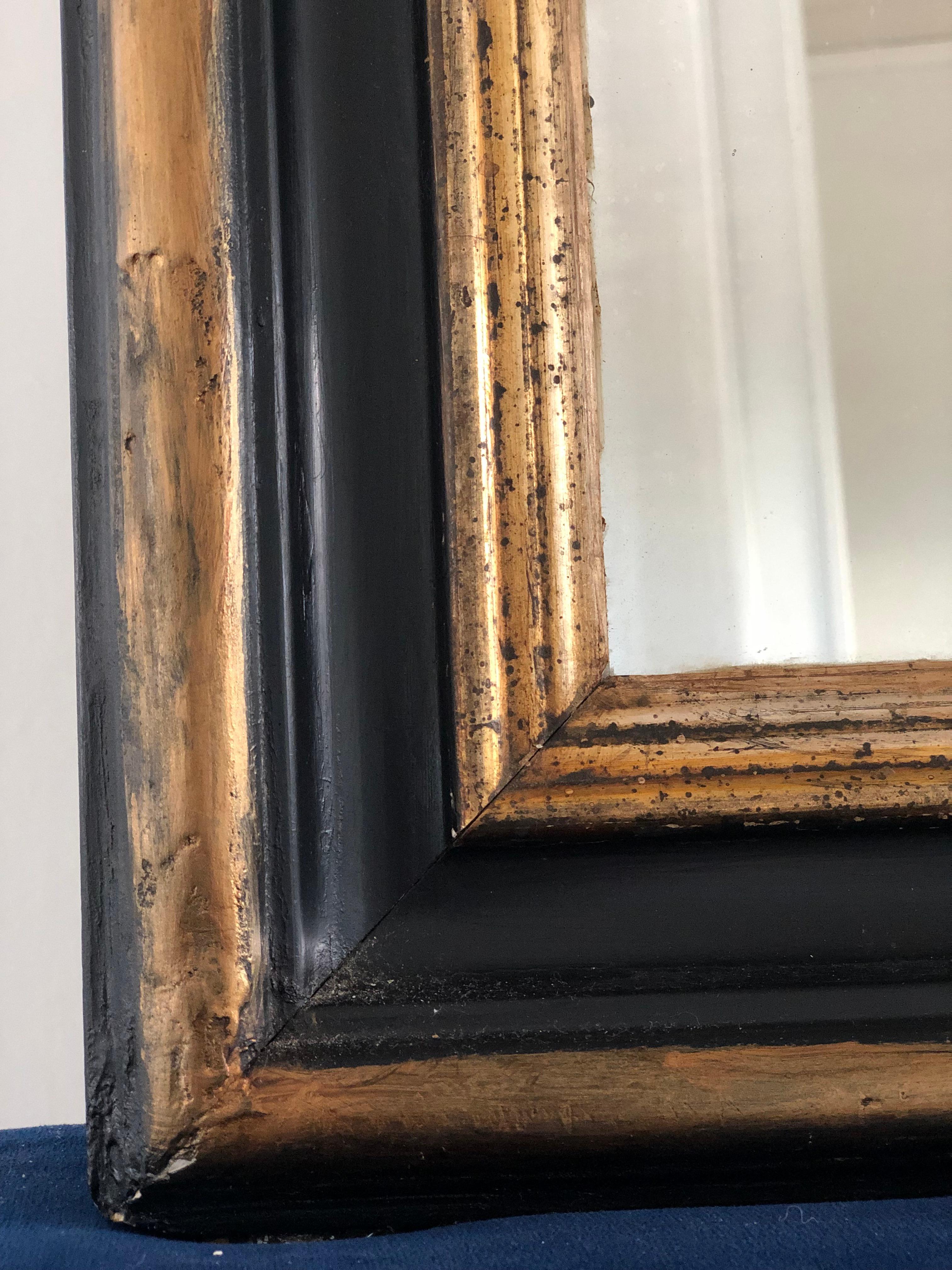 Miroir ancien Louis Philippe de très grande qualité, datant de la fin du 19e siècle et provenant de France. Une apparition avec grandeur. Le cadre en bois doré richement sculpté avec les coins supérieurs incurvés présente une belle patine usée à la