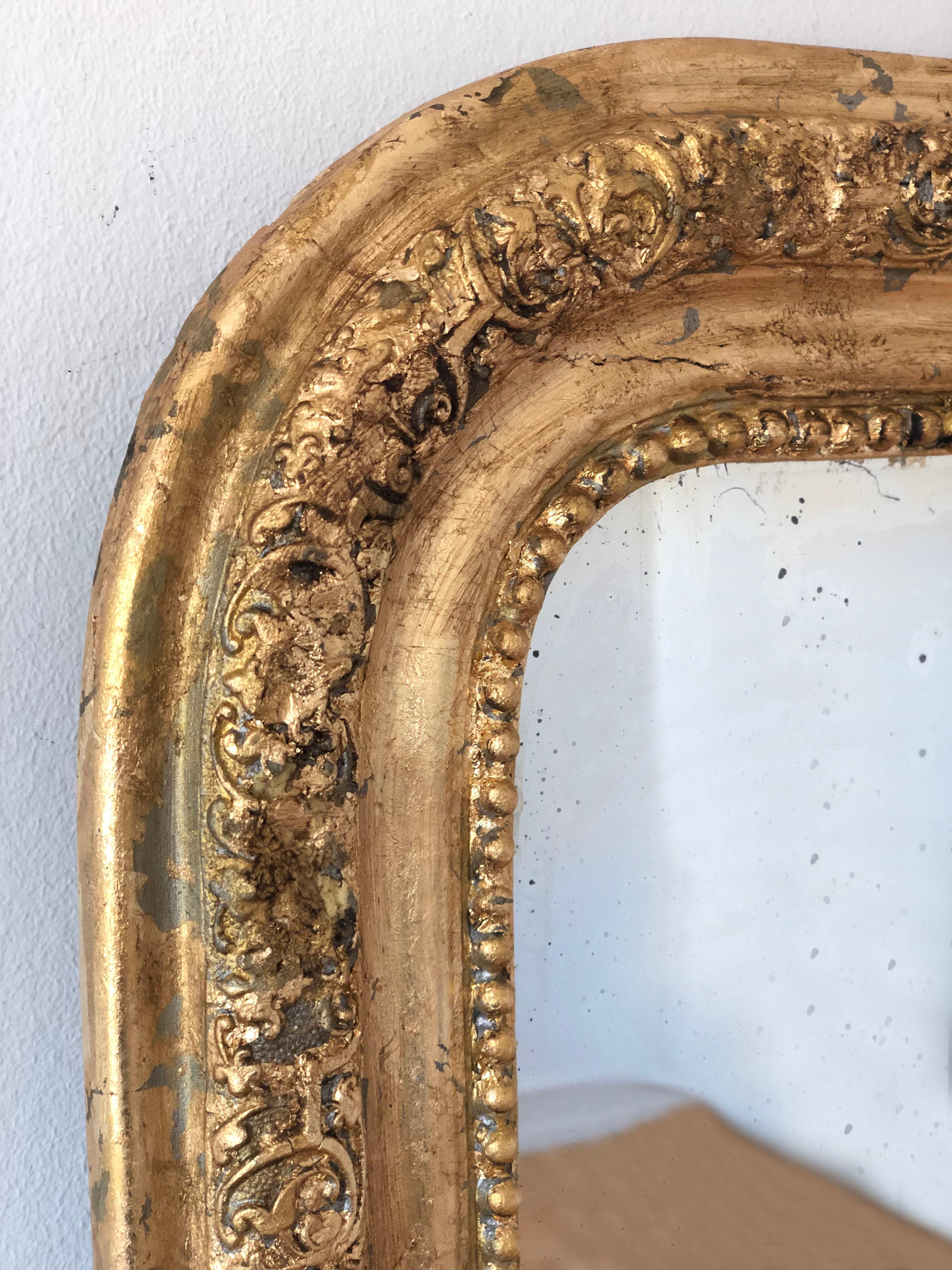 A very high-quality antique Louis Philippe mirror from France, dating to the late 19th century.
With an appearance of grandeur, the richly carved giltwood frame features gracefully curved top corners, a beautiful worn gold leaf patina, and a