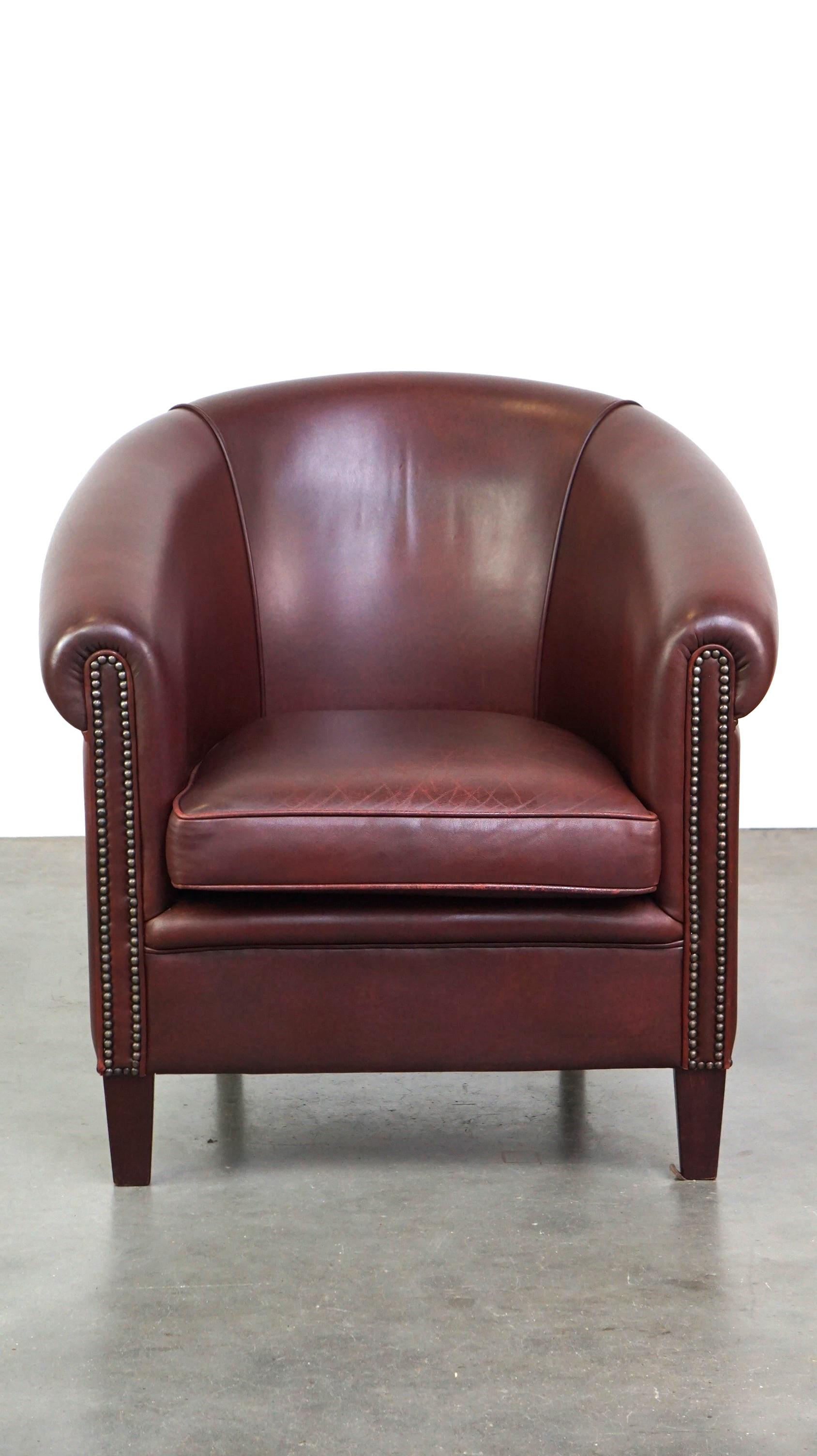 This lovely cowhide leather club chair has a unique color, making it a real eye-catcher. It can be easily placed in almost any interior and any room. This chair offers comfortable seating and features a sleek finish with decorative nails and a black