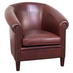 Fauteuil club en cuir de vachette de haute qualité dans un style anglais classique.