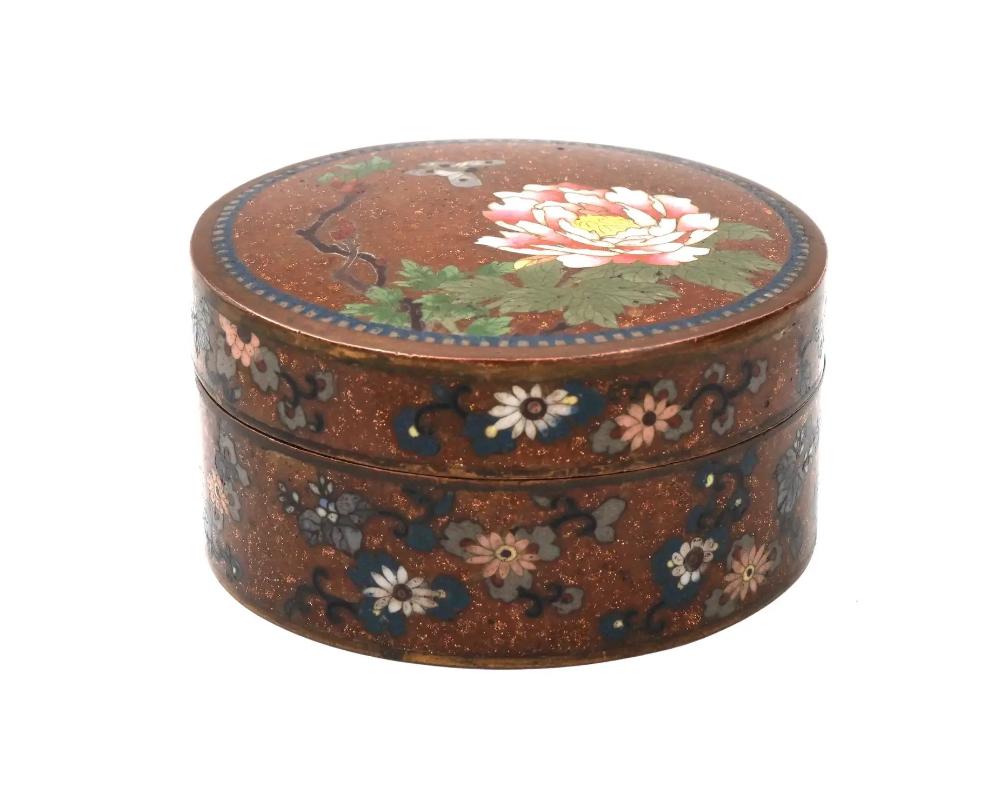 A high quality Japanese goldstone ground and cloisonne enamel trinket or jewelry box, Meiji Period, Japan. Of a round shape, the lid is decorated with a beutifully detailed cloisonne enamel scene depicting a peony flower and a butterfly. The sides